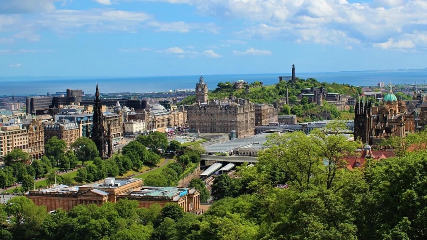 Edinburgh’s historic skyline extends toward the Firth of Forth under a blue sky.