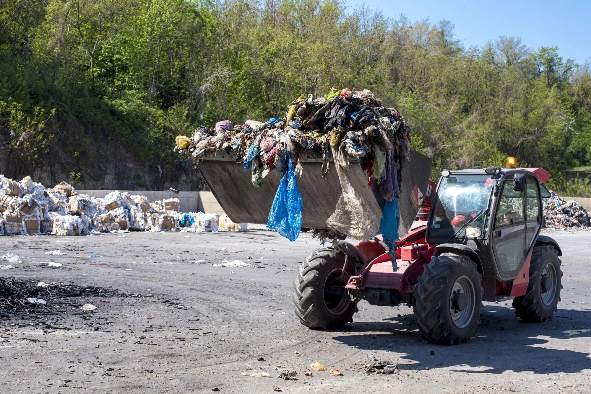 Wheel loader moving municipal waste at a treatment facility.