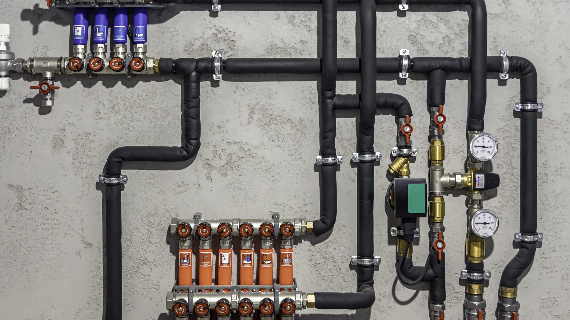 Pipes, pumps, valves, and control equipment inside a modern boiler room.