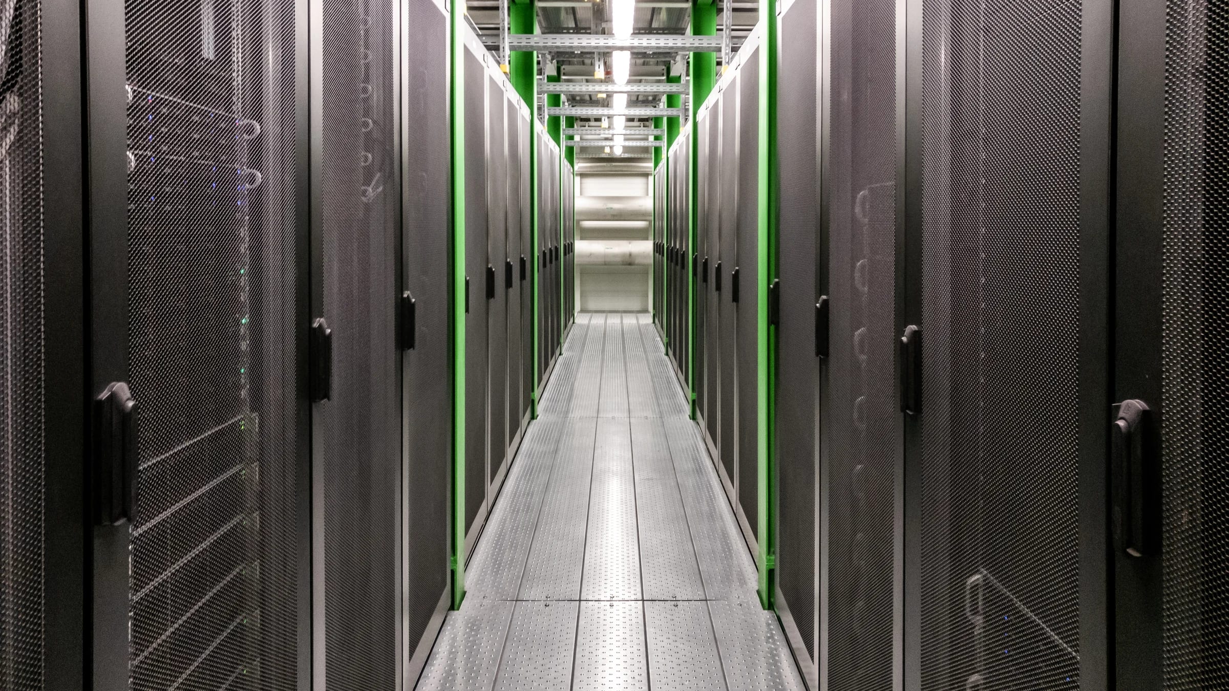 Rows of illuminated server cabinets form a corridor inside a data centre.