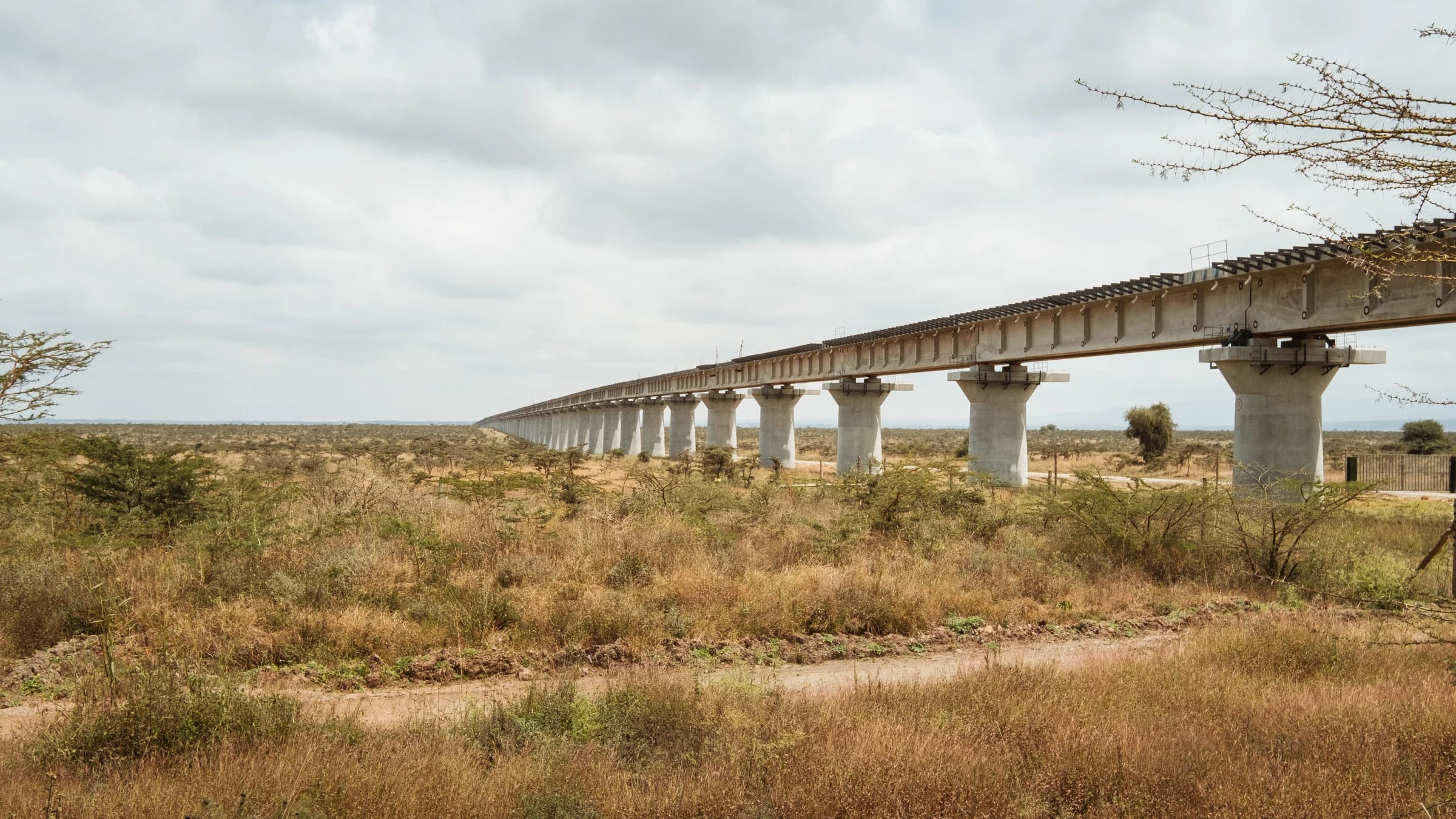 Long elevated bridge crossing dry terrain beneath a cloudy sky near Nairobi.