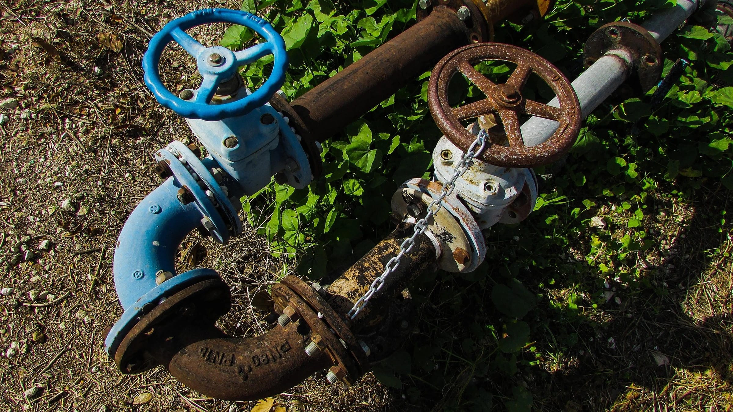 Water pipes with blue and rust-colored valve handwheels