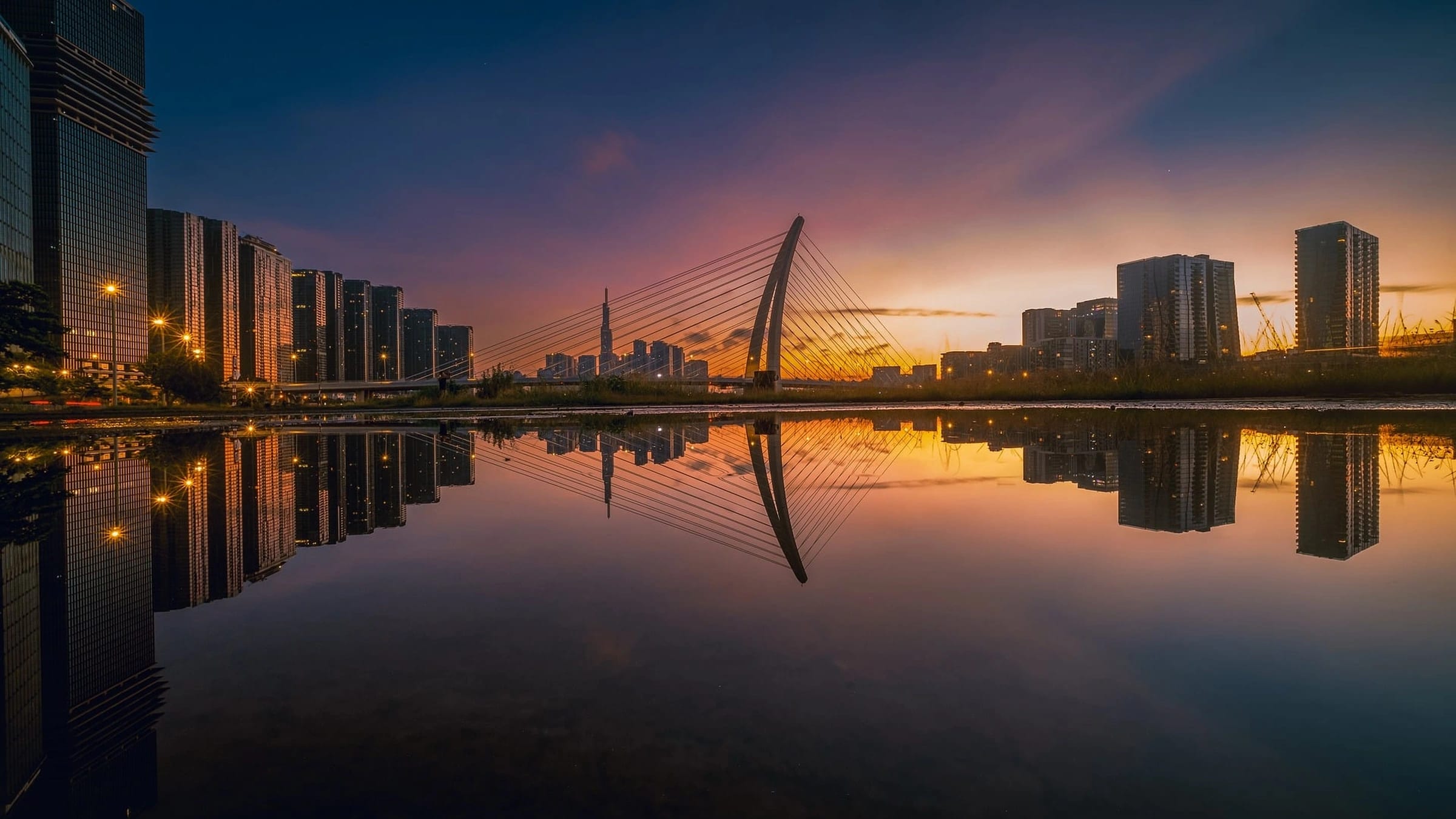 Ba Son Bridge and riverfront buildings in Ho Chi Minh City at sunset