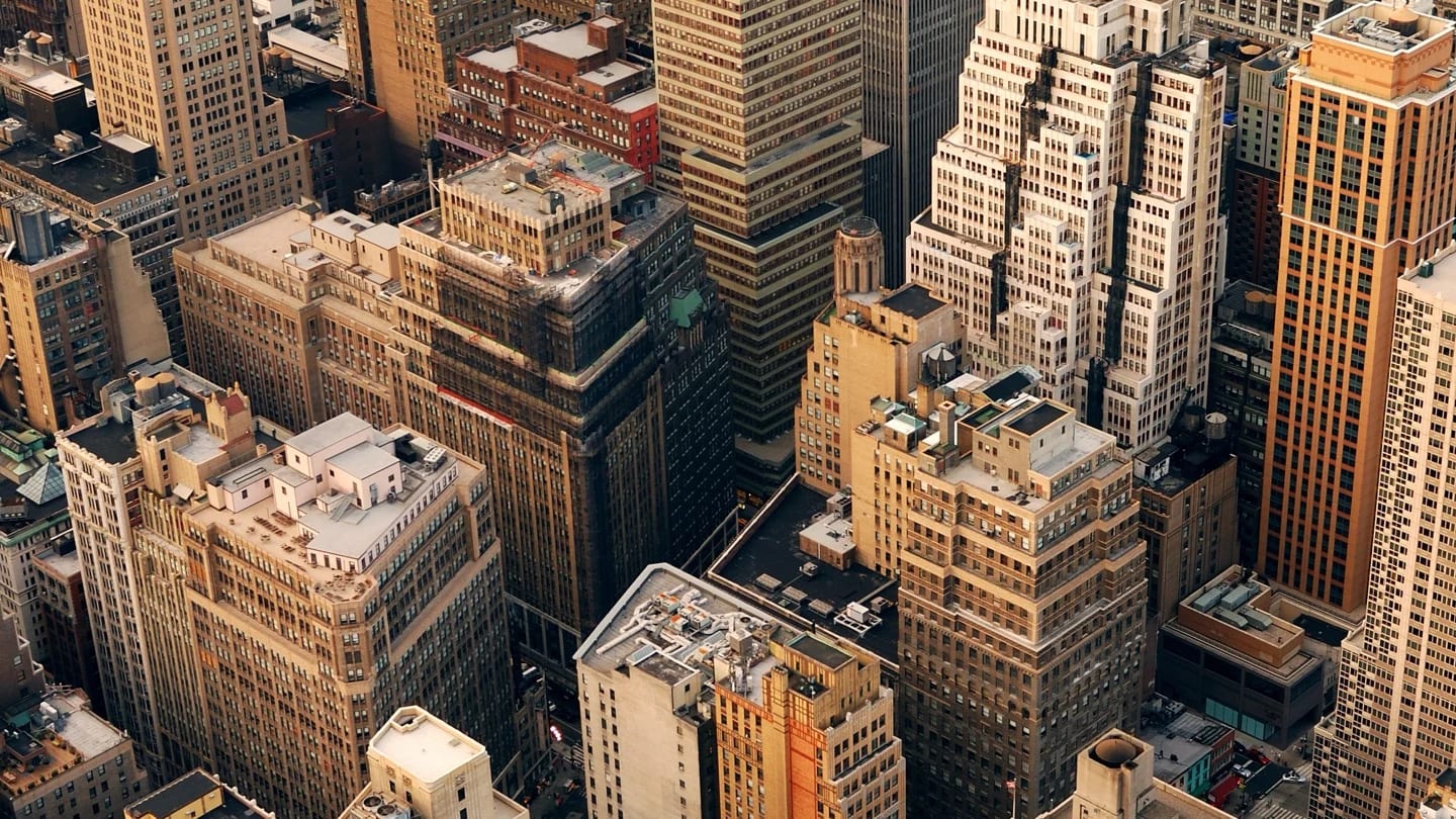 A dense city center seen from above, with high-rise buildings and streets packed closely together.