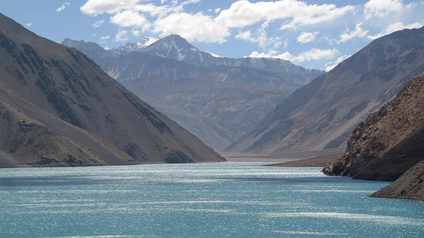 Turquoise Andean reservoir framed by steep mountain slopes in central Chile.