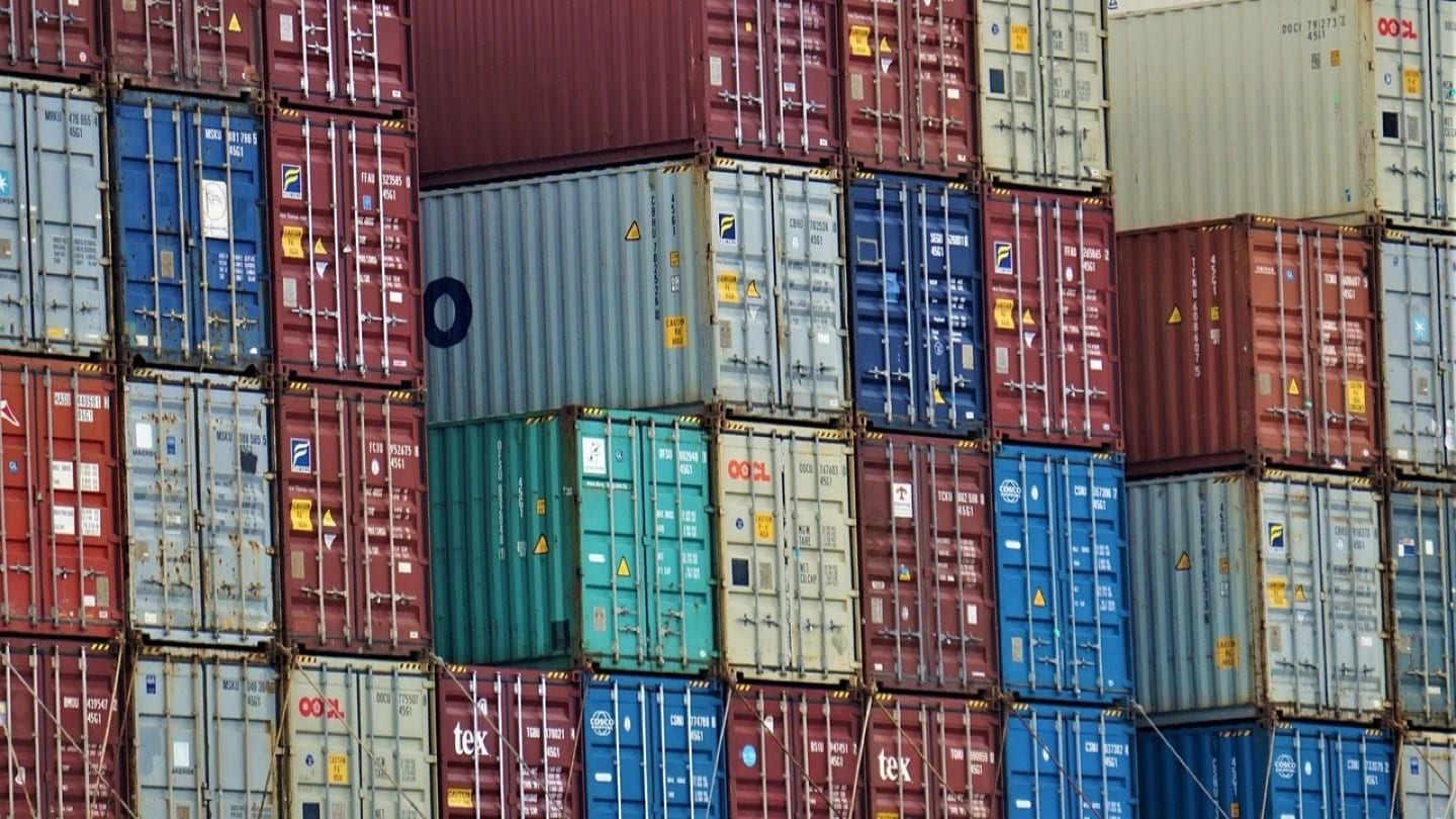 Stacks of multicolored cargo containers fill a freight terminal.