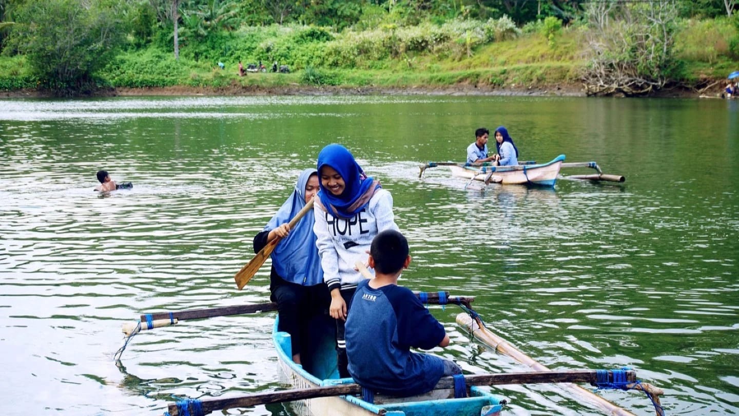 People travel by small boats across a reservoir in Indonesia.