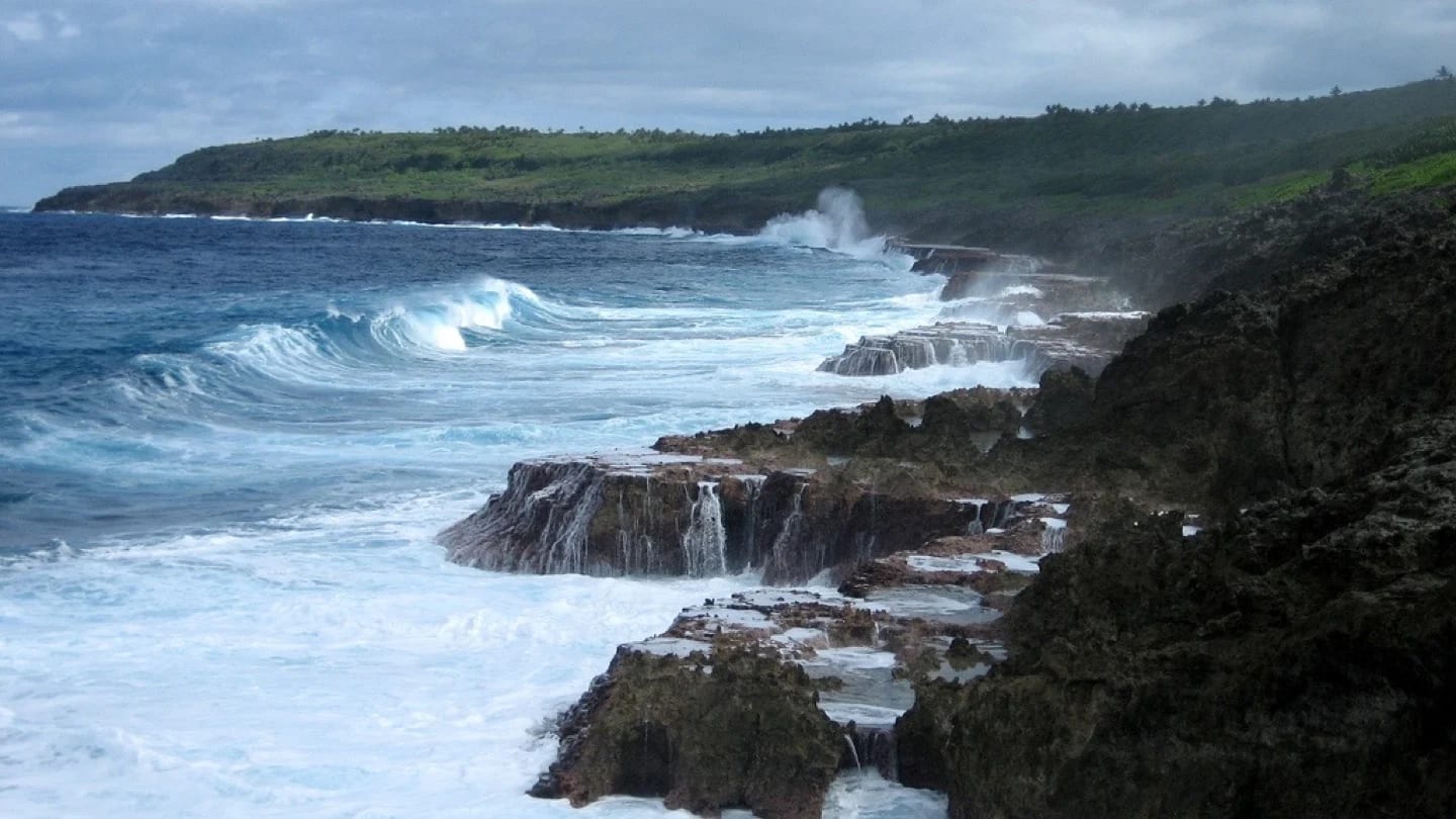 Waves break across Niue’s rugged limestone coastline.