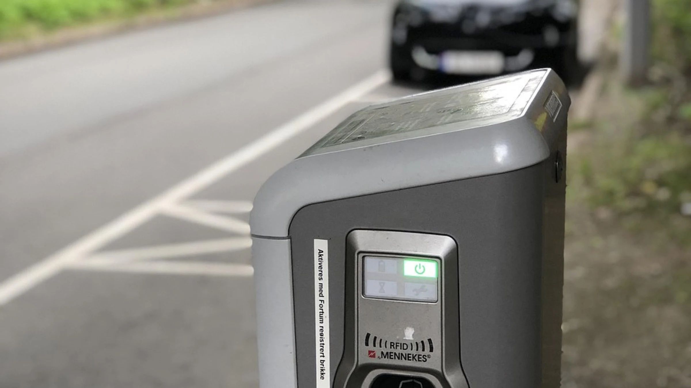 An electric-vehicle charging point beside parked cars.