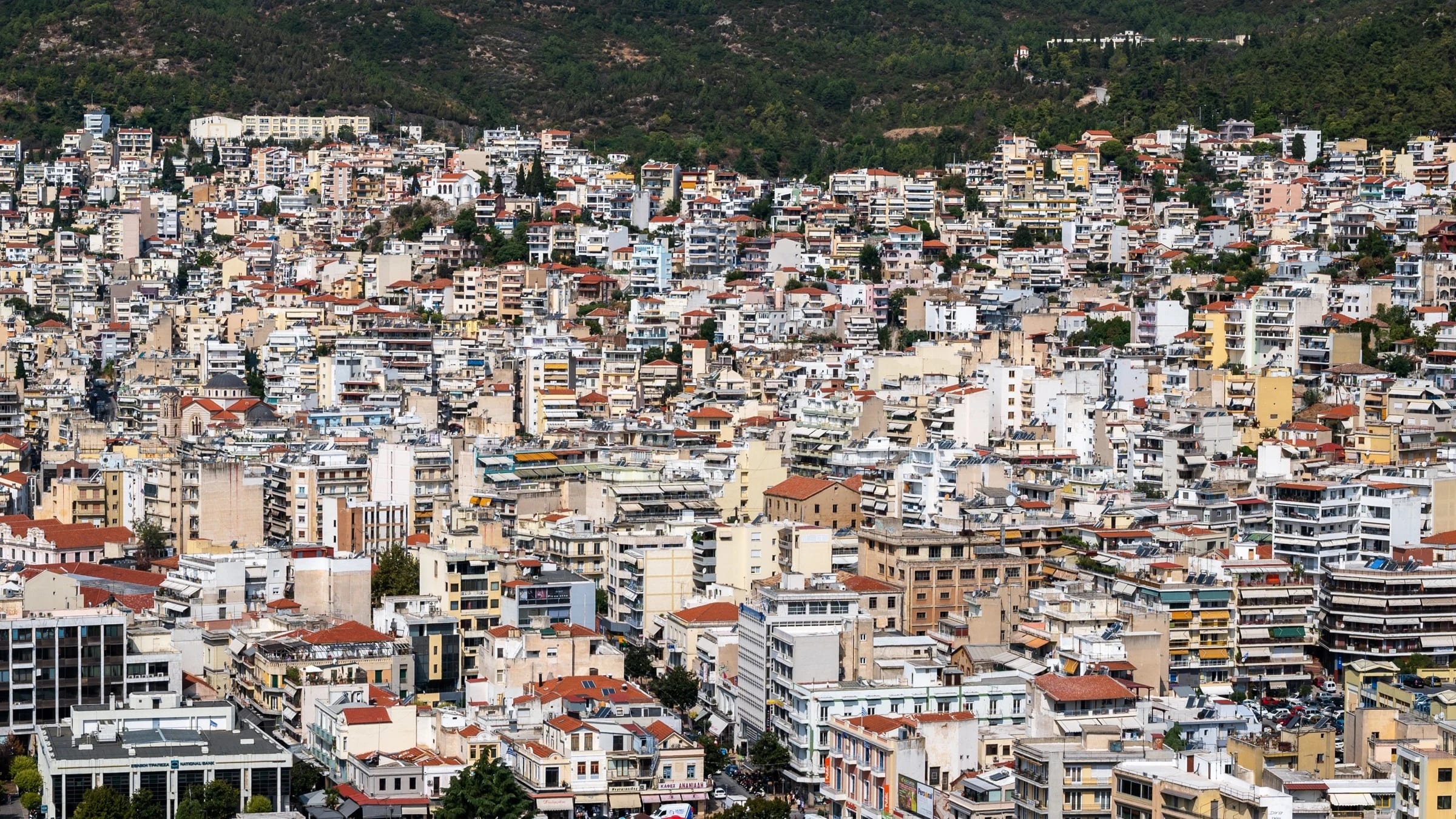 Dense residential buildings climb a hillside in Kavala, Greece.