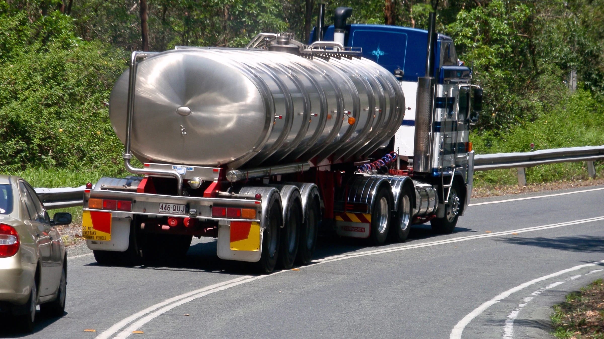 Large water tanker truck travelling on a road.