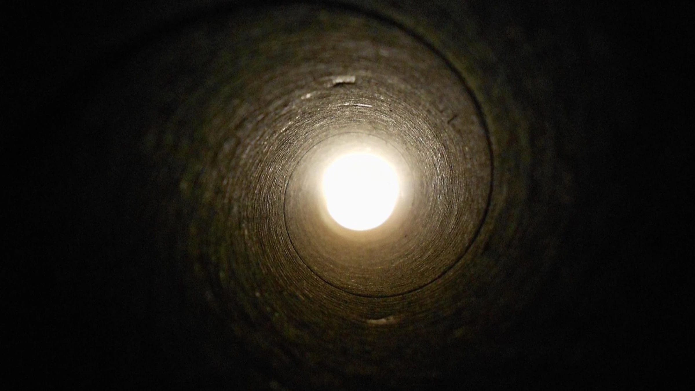 View through a large underground pipe or service tunnel.
