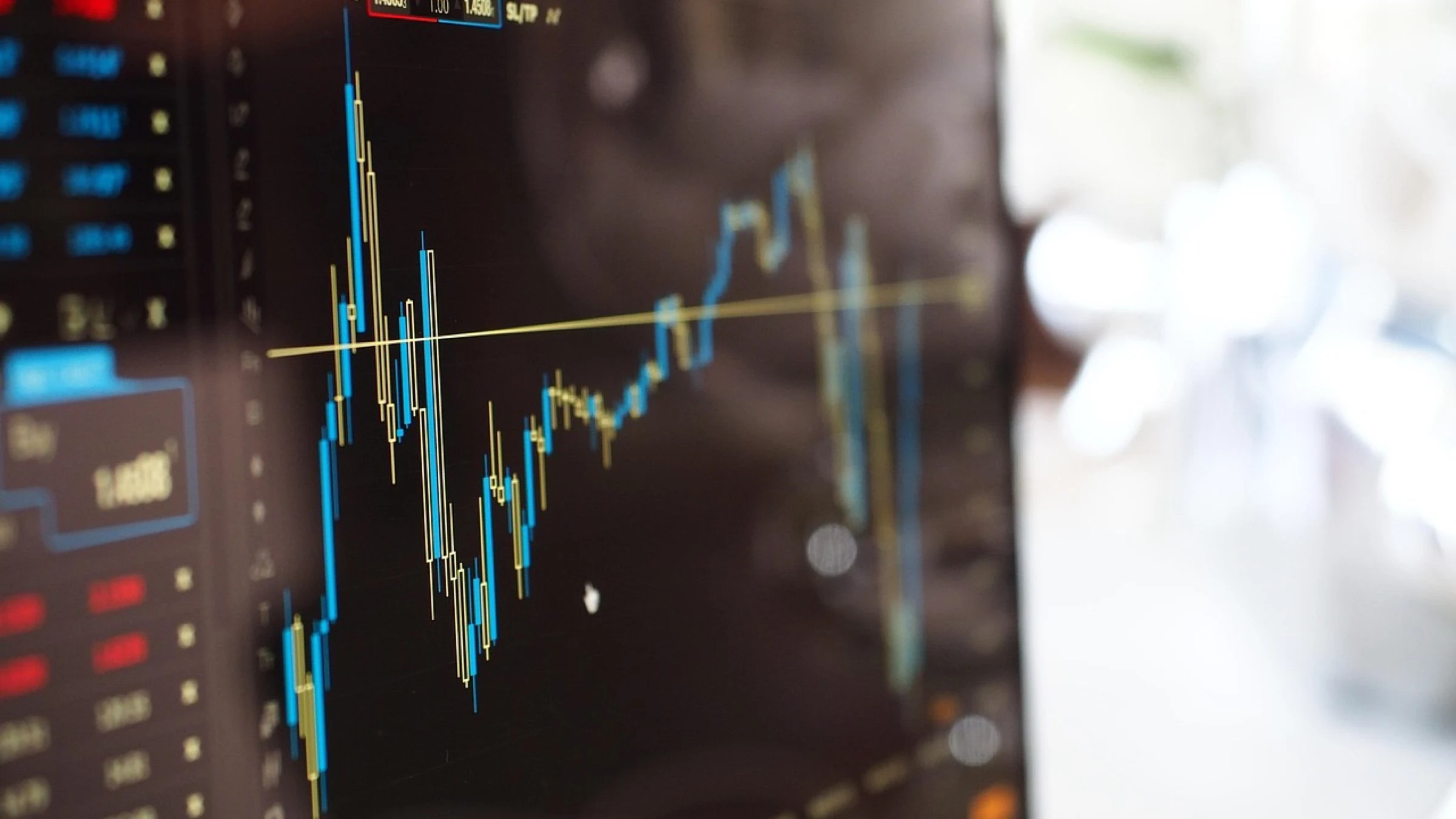 Financial chart beside a computer in a blurred office setting.