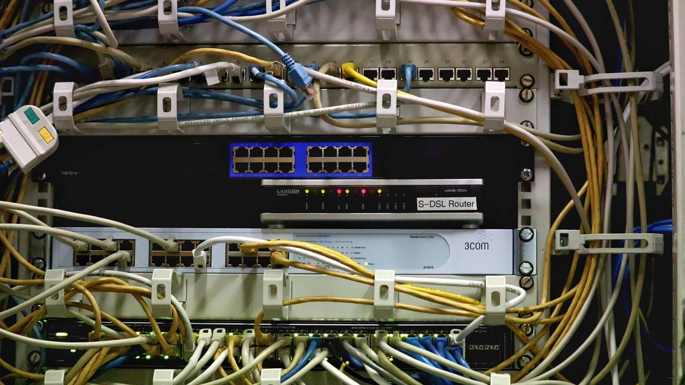 Network cables connected to routers and switches in an equipment rack.