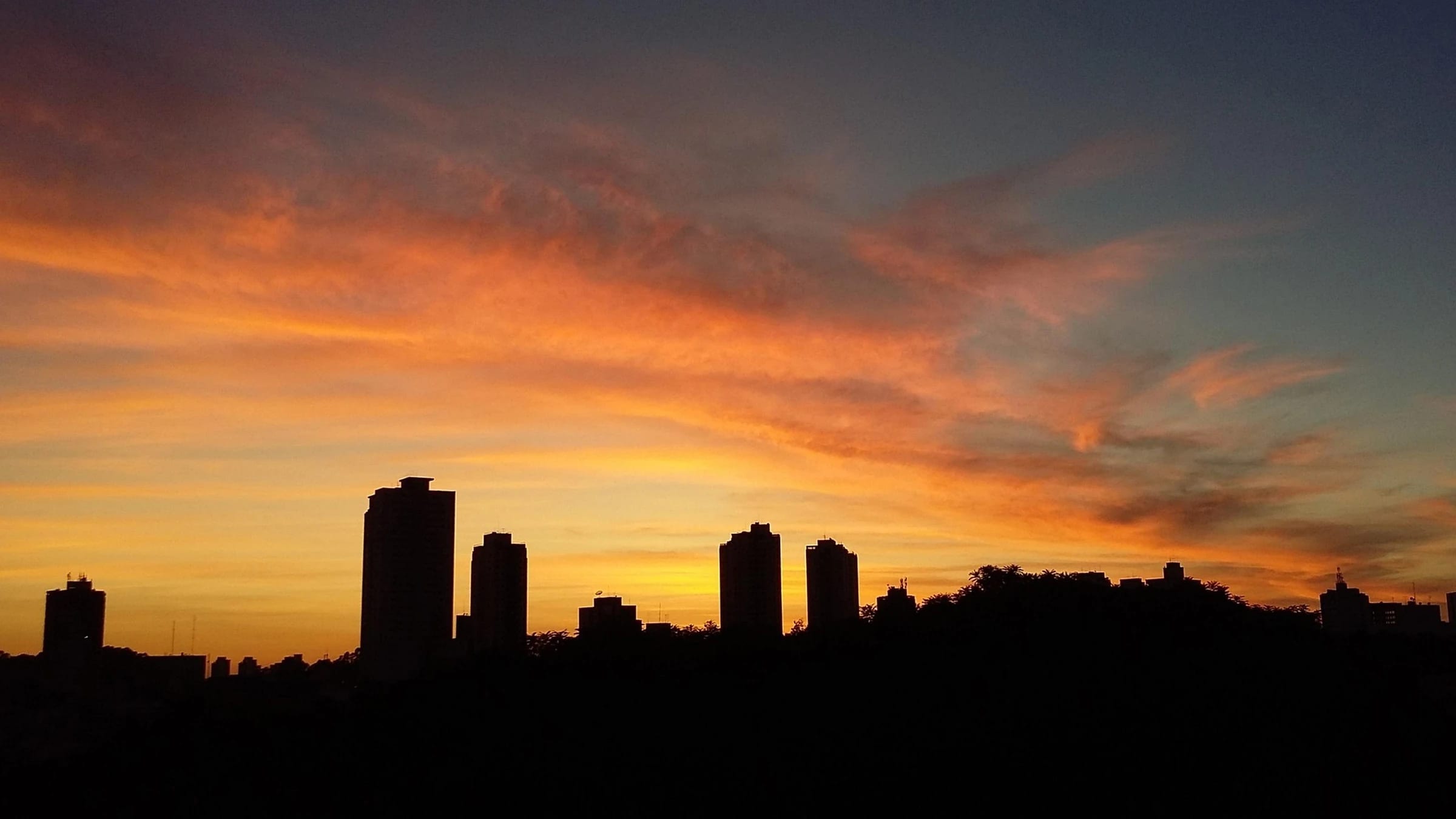 São Paulo skyline silhouetted against the dawn sky.