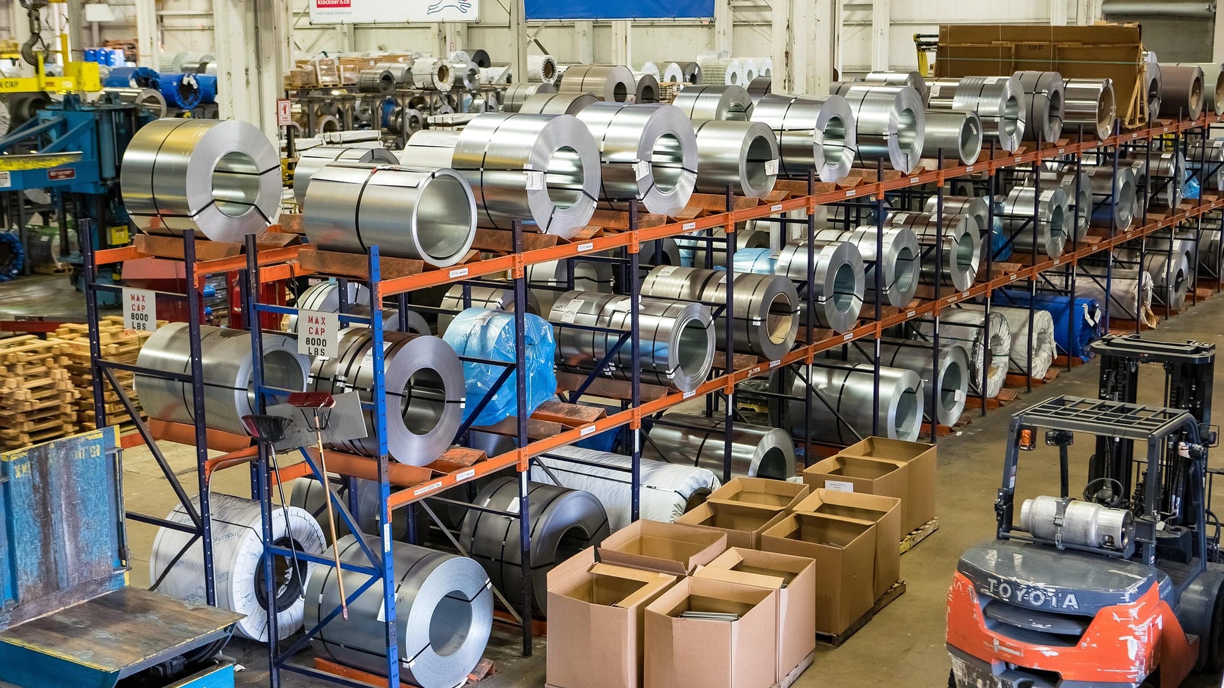 Stored materials and coils in an industrial warehouse.