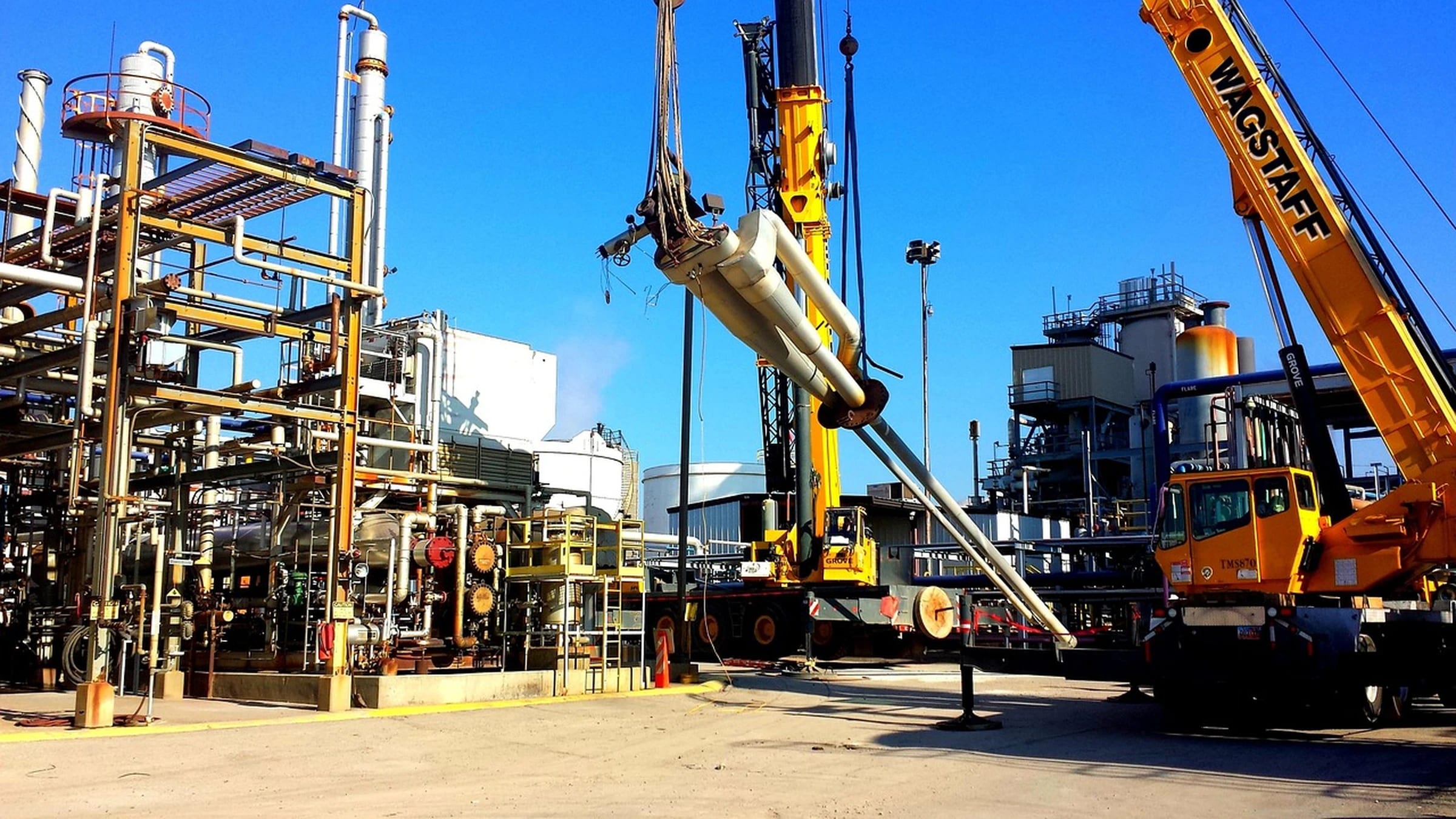 Industrial fuel-processing structures and pipework beneath a blue sky