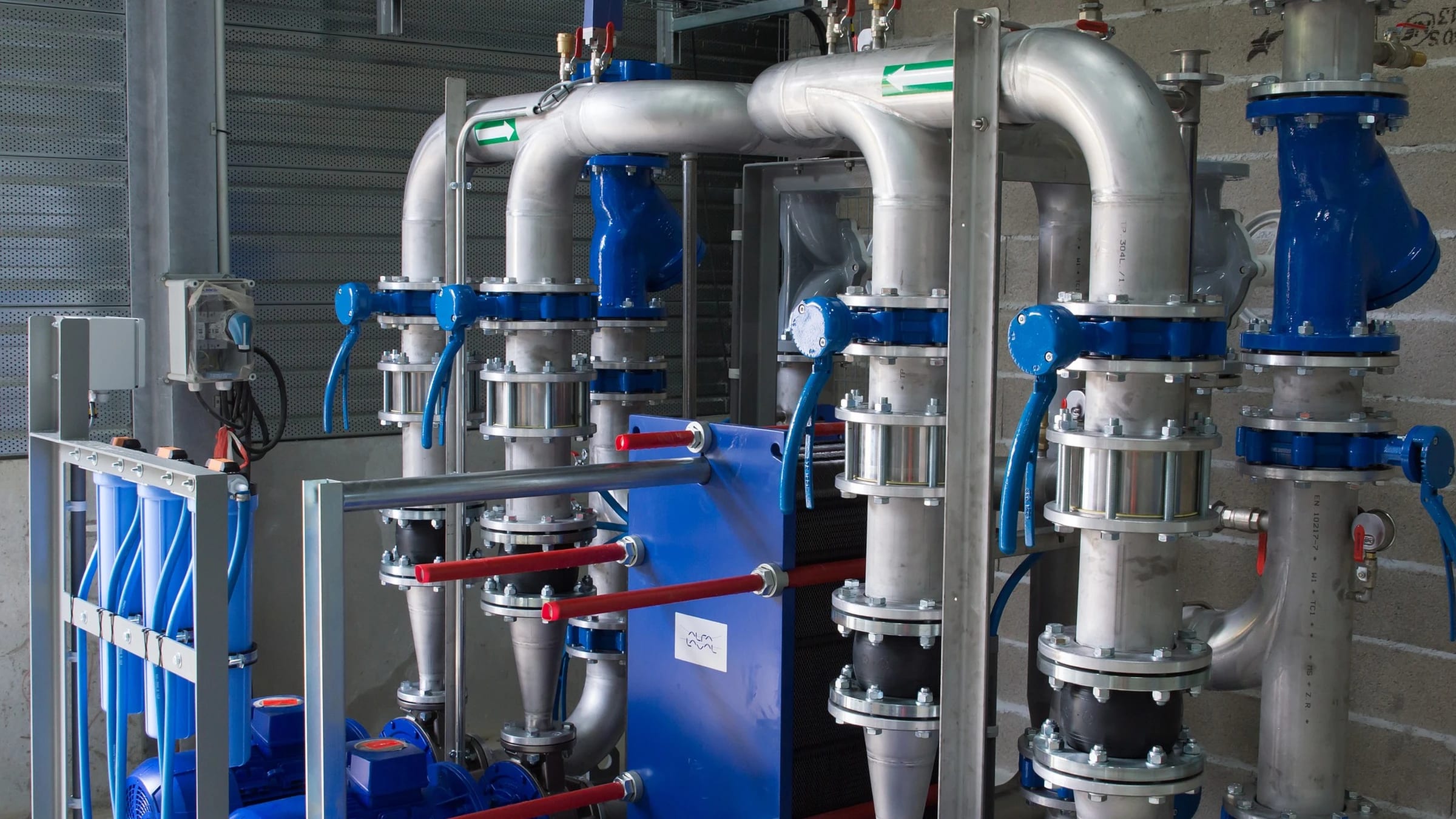 Industrial pump and valve assemblies with blue equipment and silver pipes.