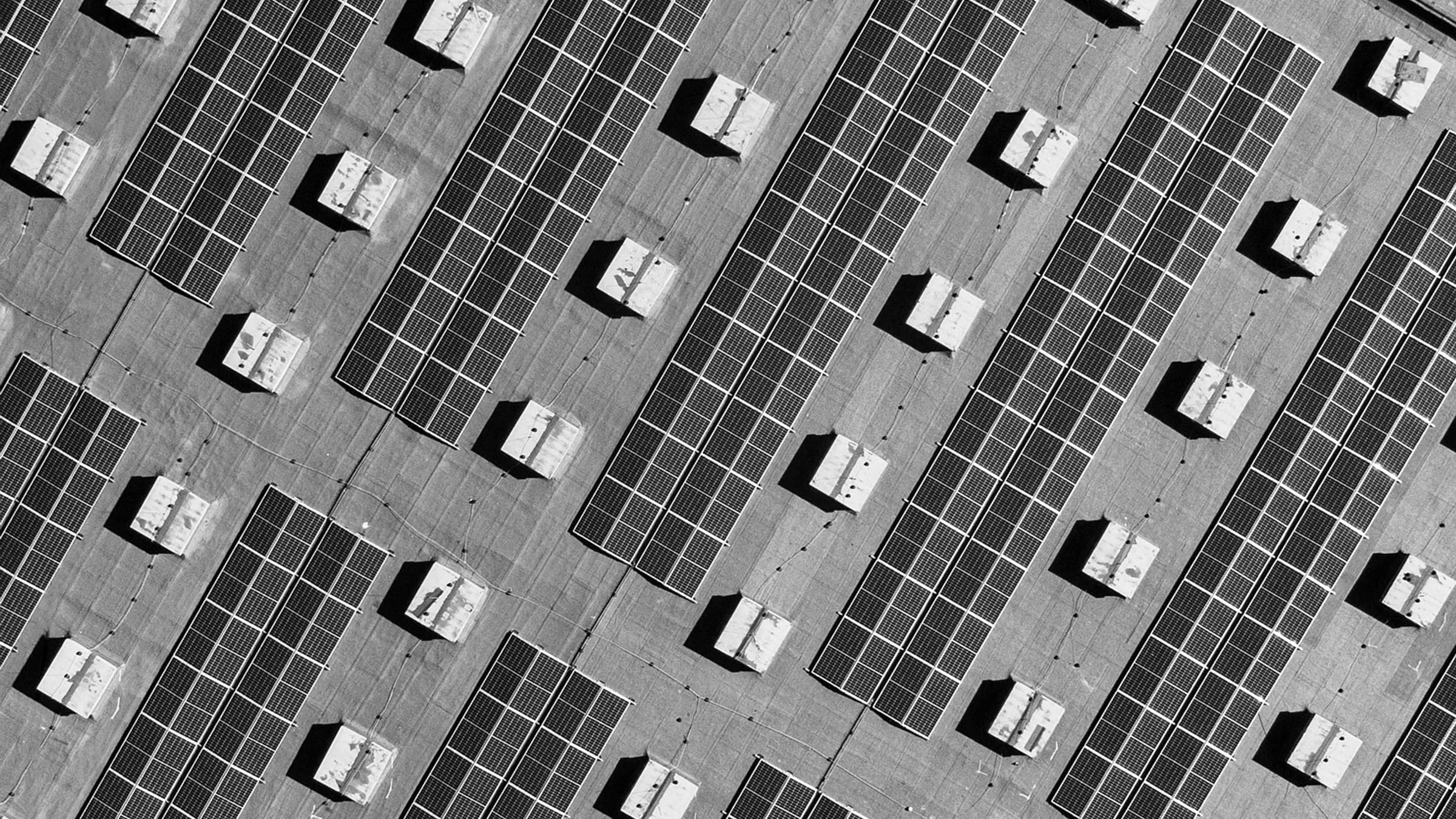 Overhead view of rows of solar panels on a roof.