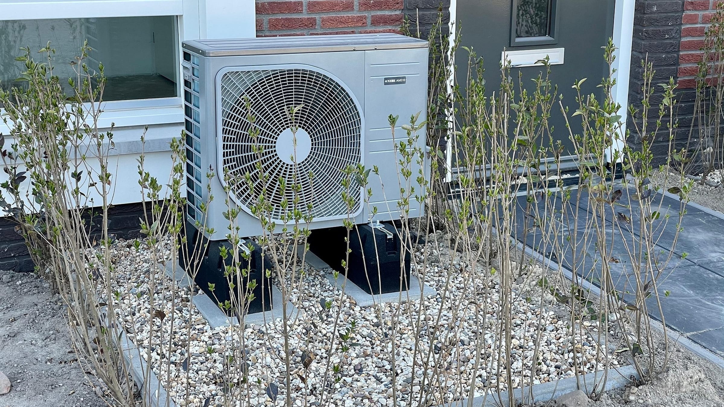 Outdoor heat pump equipment beside a house.
