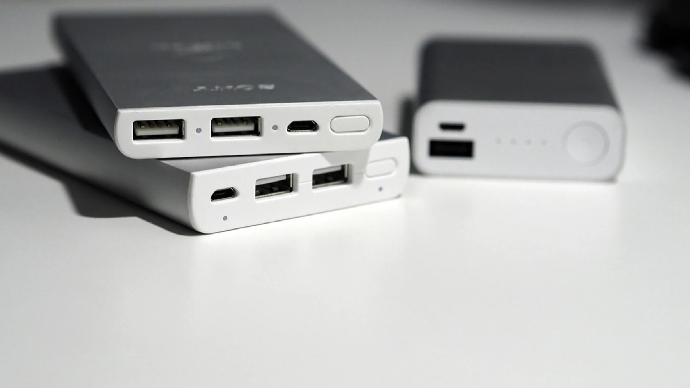 Portable power banks with charging ports on a tabletop.