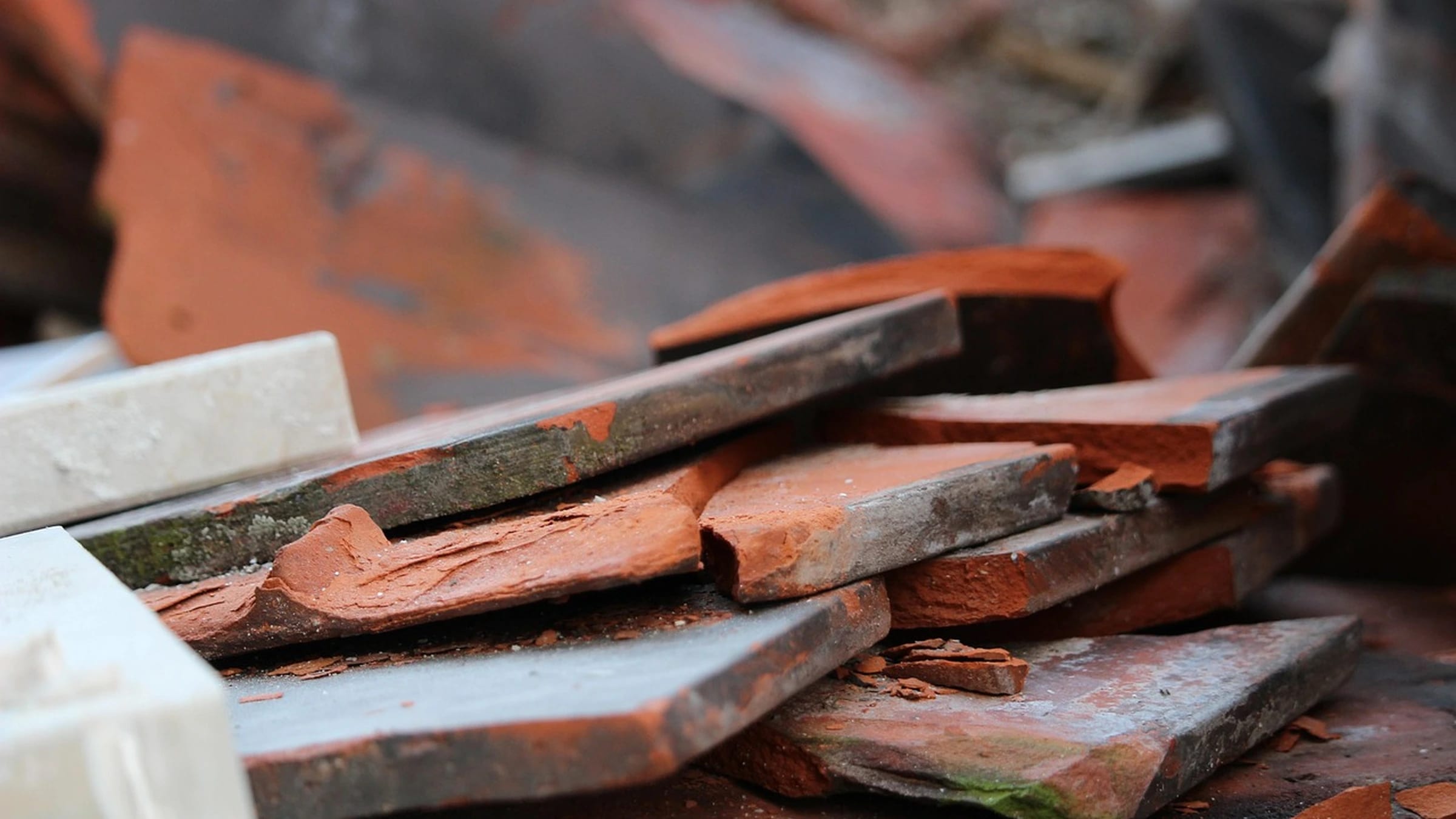 A pile of broken bricks and terracotta roof tiles.