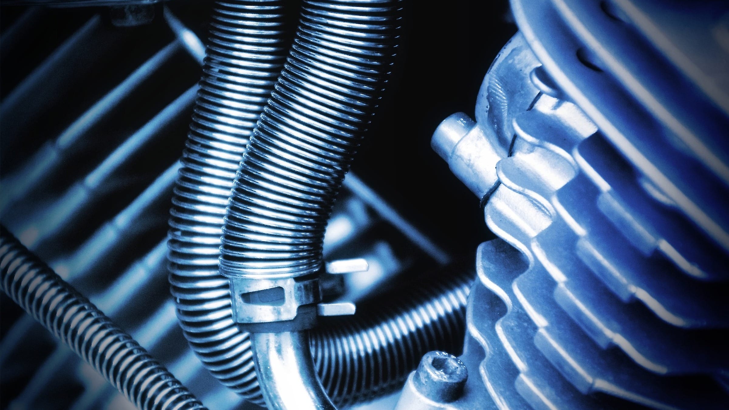 Close-up of metal engine components and connecting hoses.
