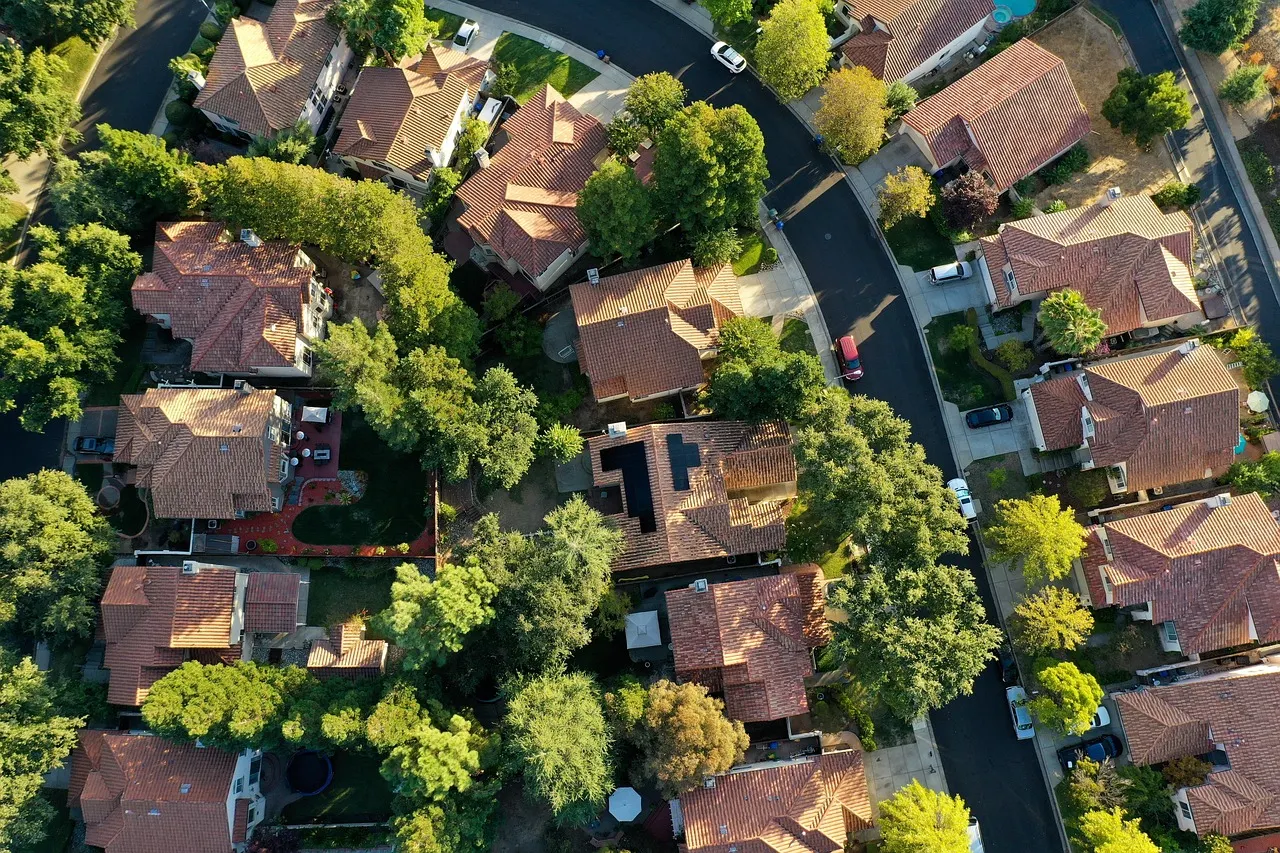 Aerial view of suburban homes with tree-lined streets illustrating residential areas that could benefit from Blue-Green Infrastructure for stormwater management.