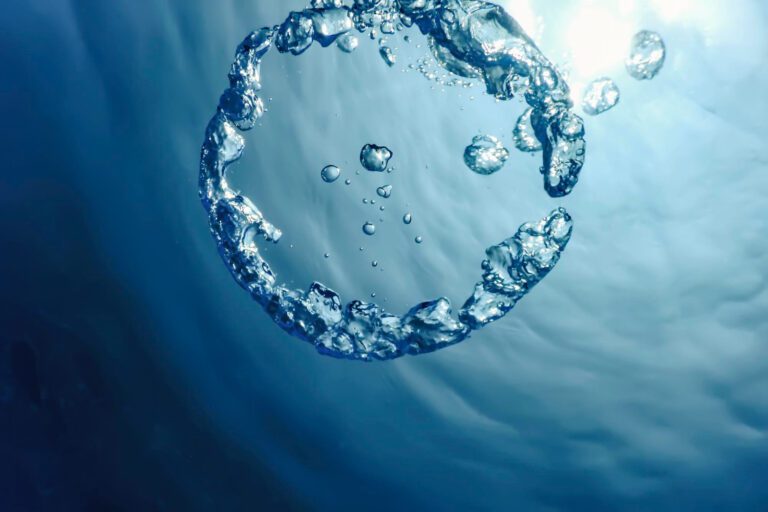 Circular formation of water droplets underwater symbolising wastewater reuse, water recycling, and climate-resilient agricultural water systems