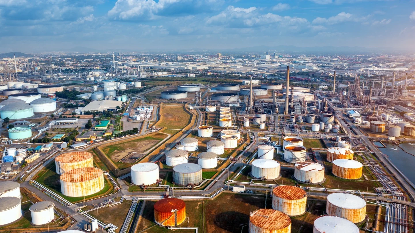An aerial view of a large fuel terminal with storage tanks, pipelines and processing infrastructure.