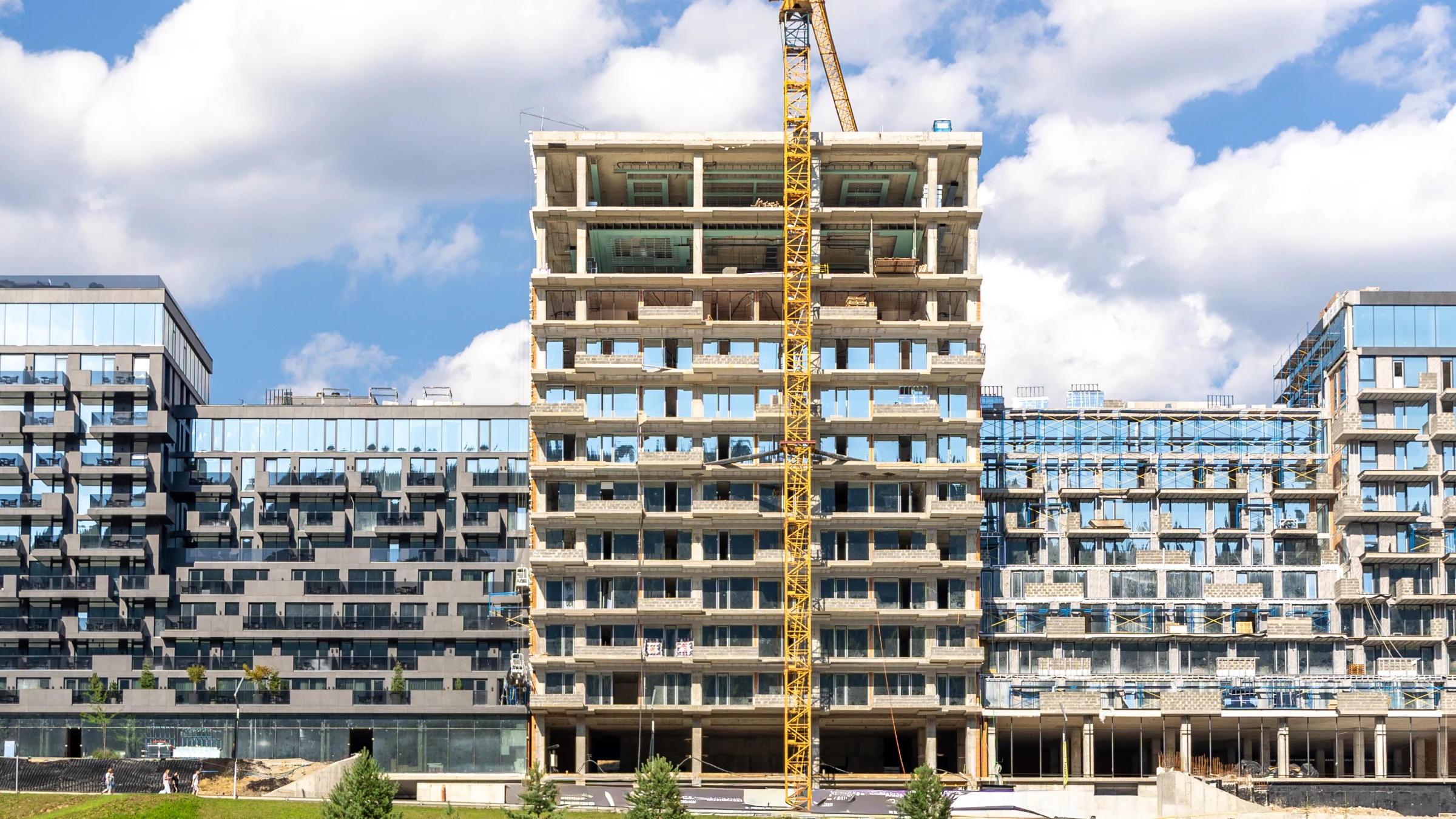 Multi-storey residential buildings under construction beside completed housing.