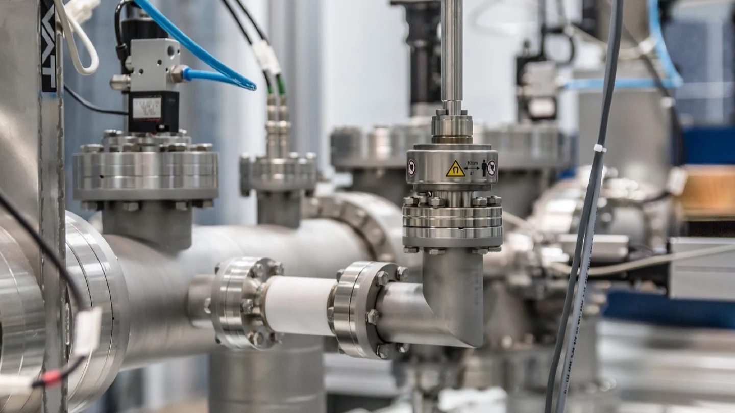 Stainless-steel industrial pipes, valves and sensors run through a process facility.