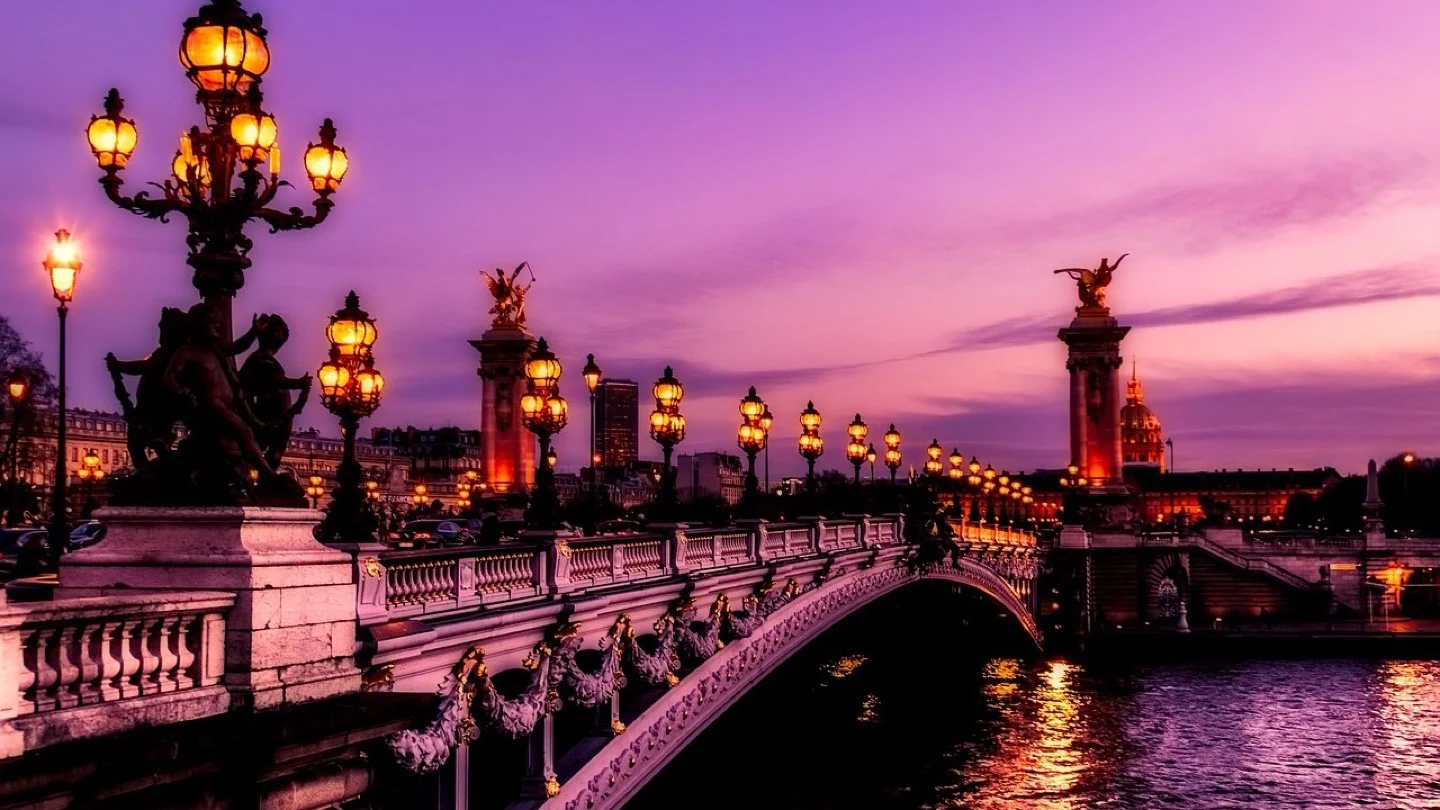 The Alexandre III Bridge crosses the Seine in Paris at sunset.
