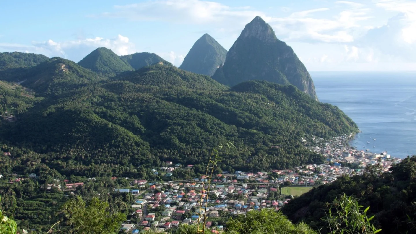 A Saint Lucian community lies beneath the Pitons beside the Caribbean Sea.