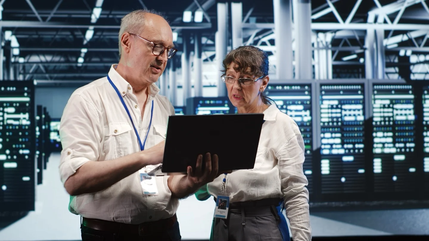 An engineer monitors illuminated server racks inside an energy-efficient data center.