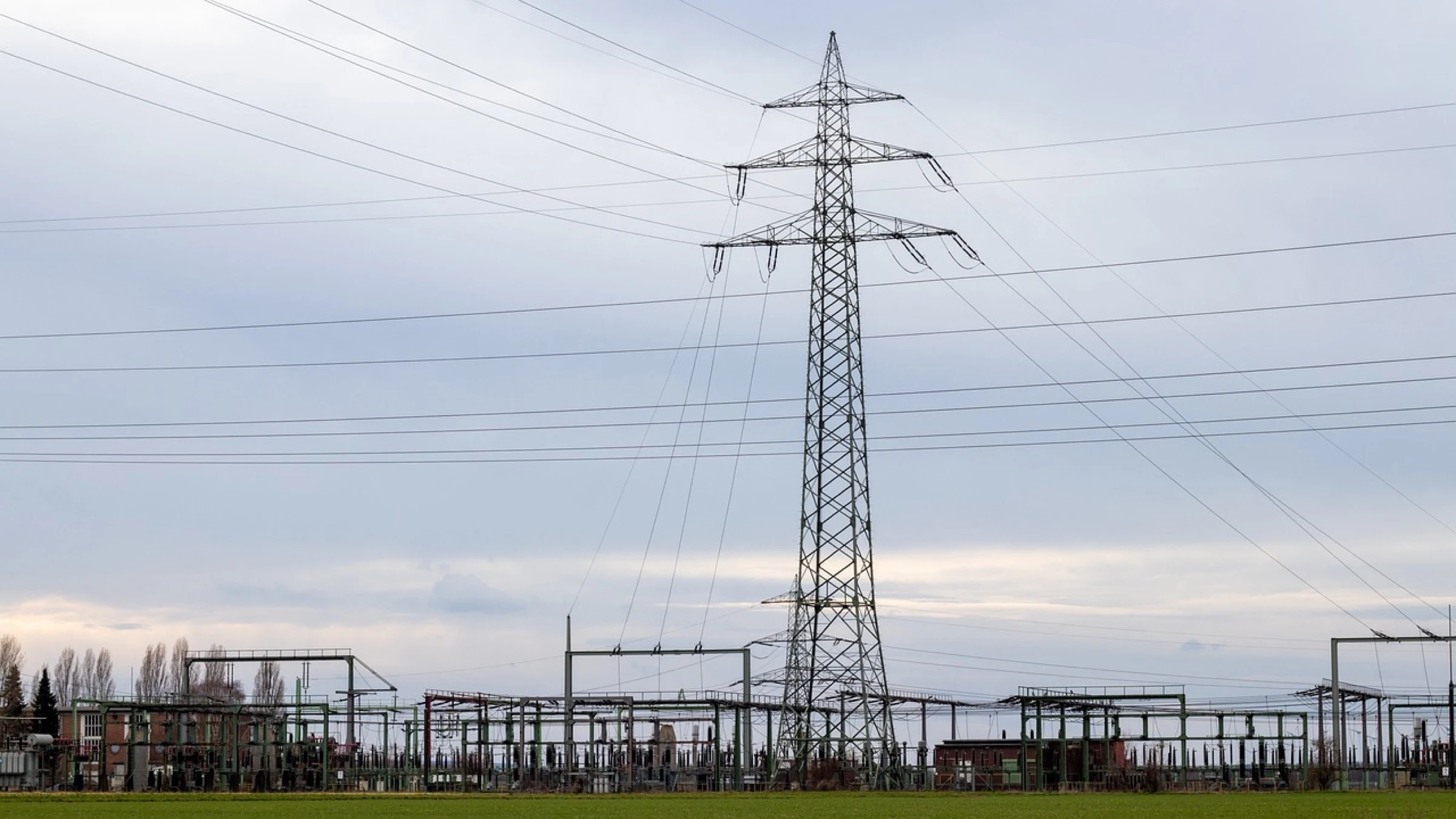 Electrical substation equipment beneath a high-voltage transmission tower.