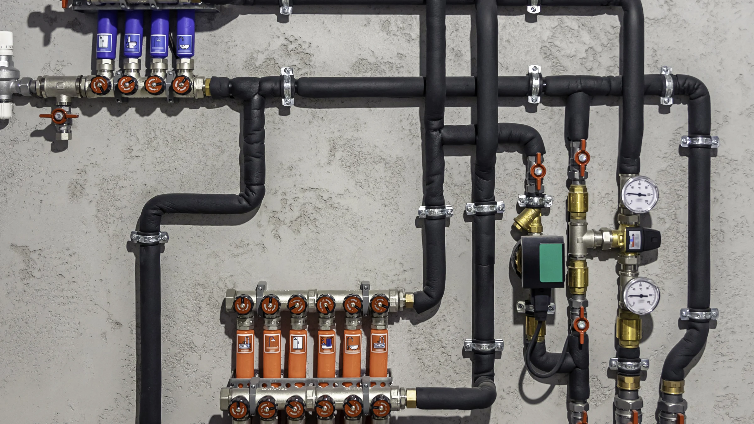 Pipes, pumps, valves, and control equipment inside a modern boiler room.