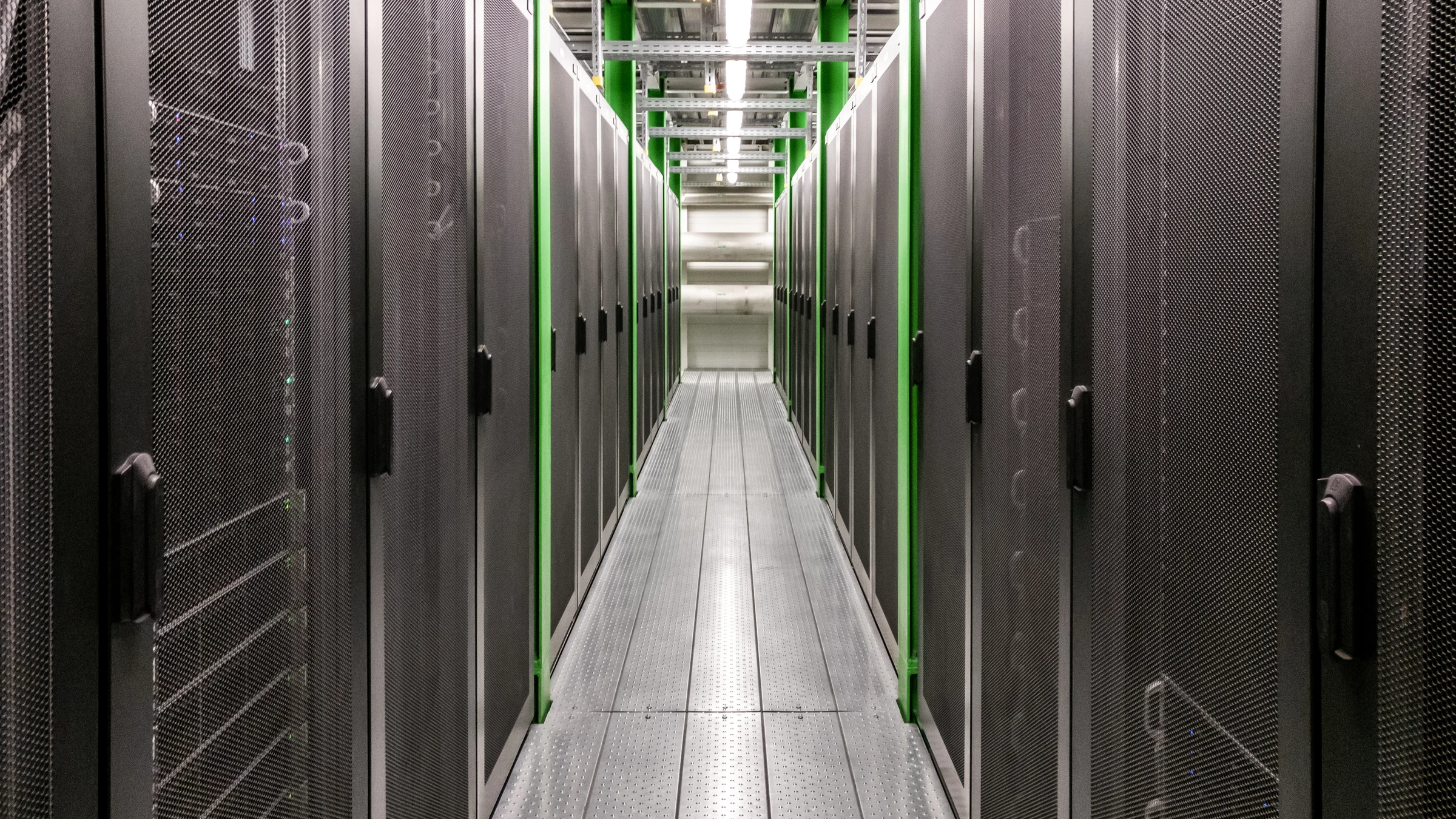 Rows of illuminated server cabinets form a corridor inside a data centre.