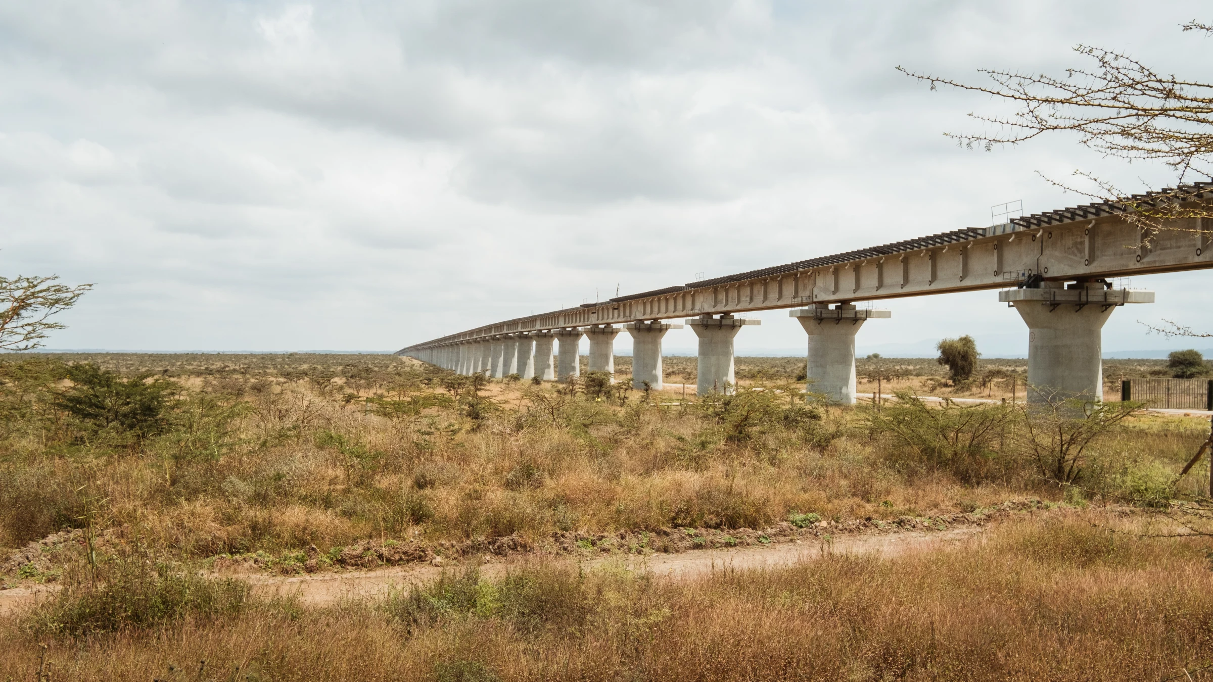 Long elevated bridge crossing dry terrain beneath a cloudy sky near Nairobi.