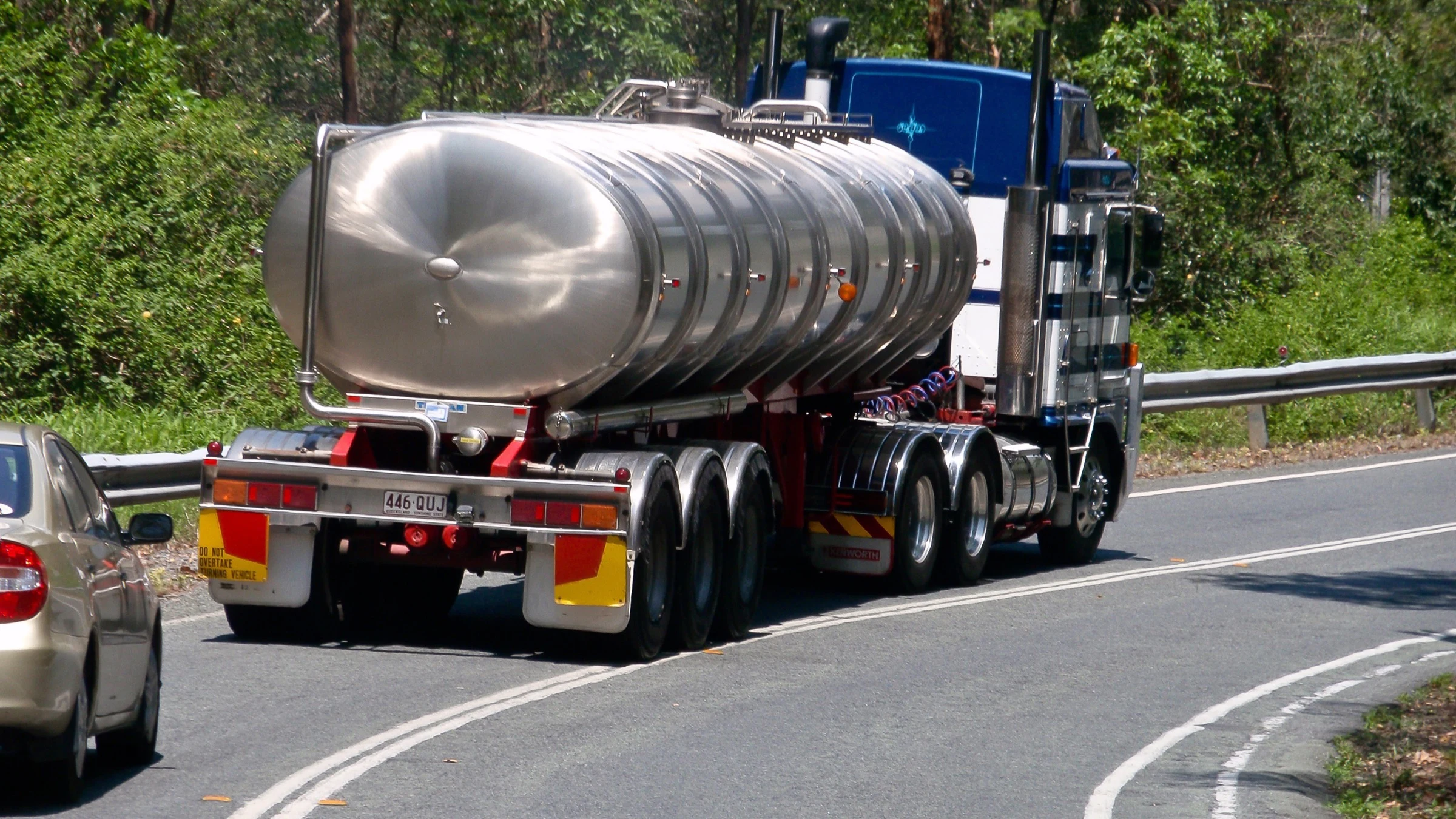 Large water tanker truck travelling on a road.