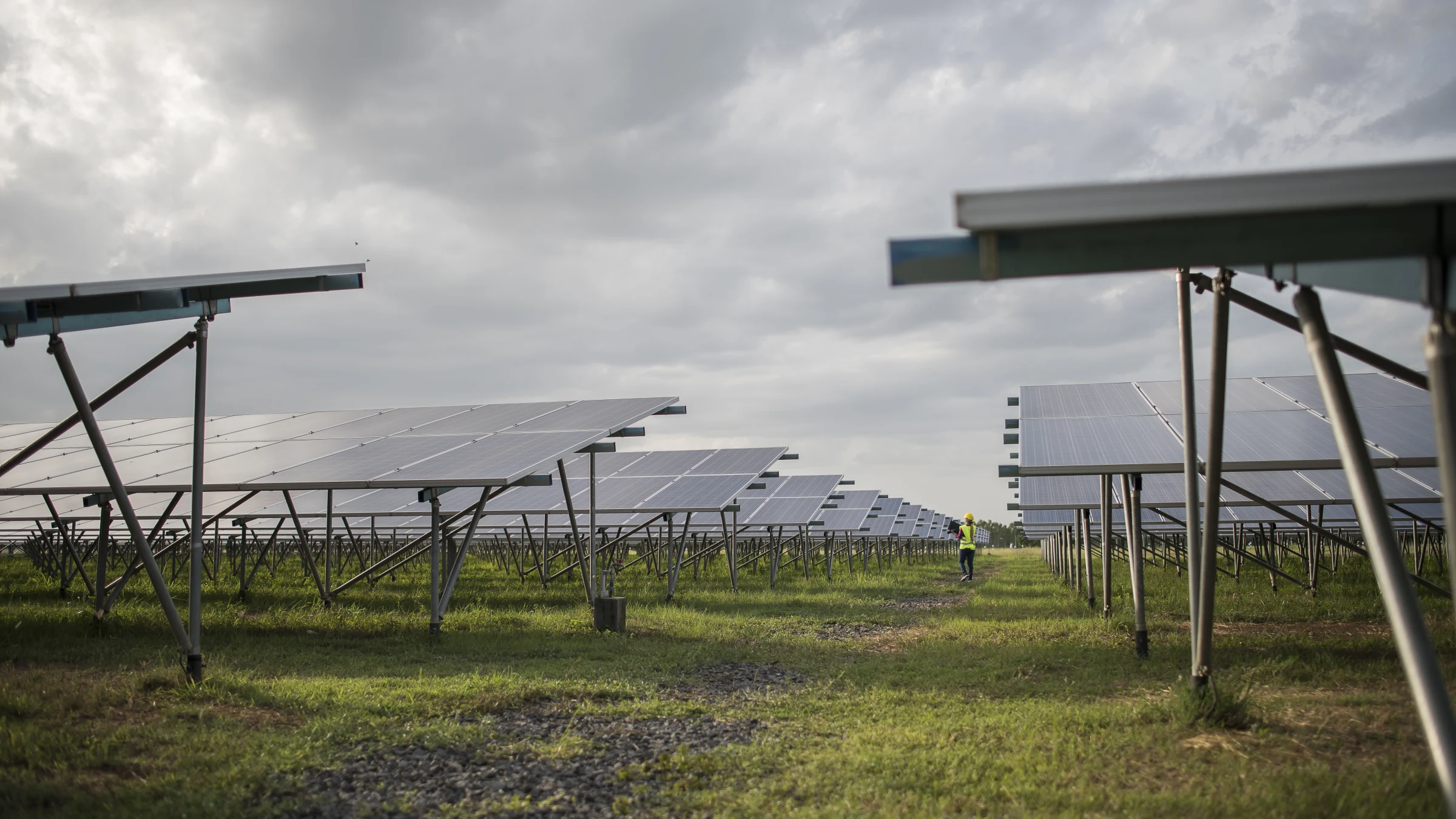 Rows of photovoltaic panels at a solar power station under open sky.
