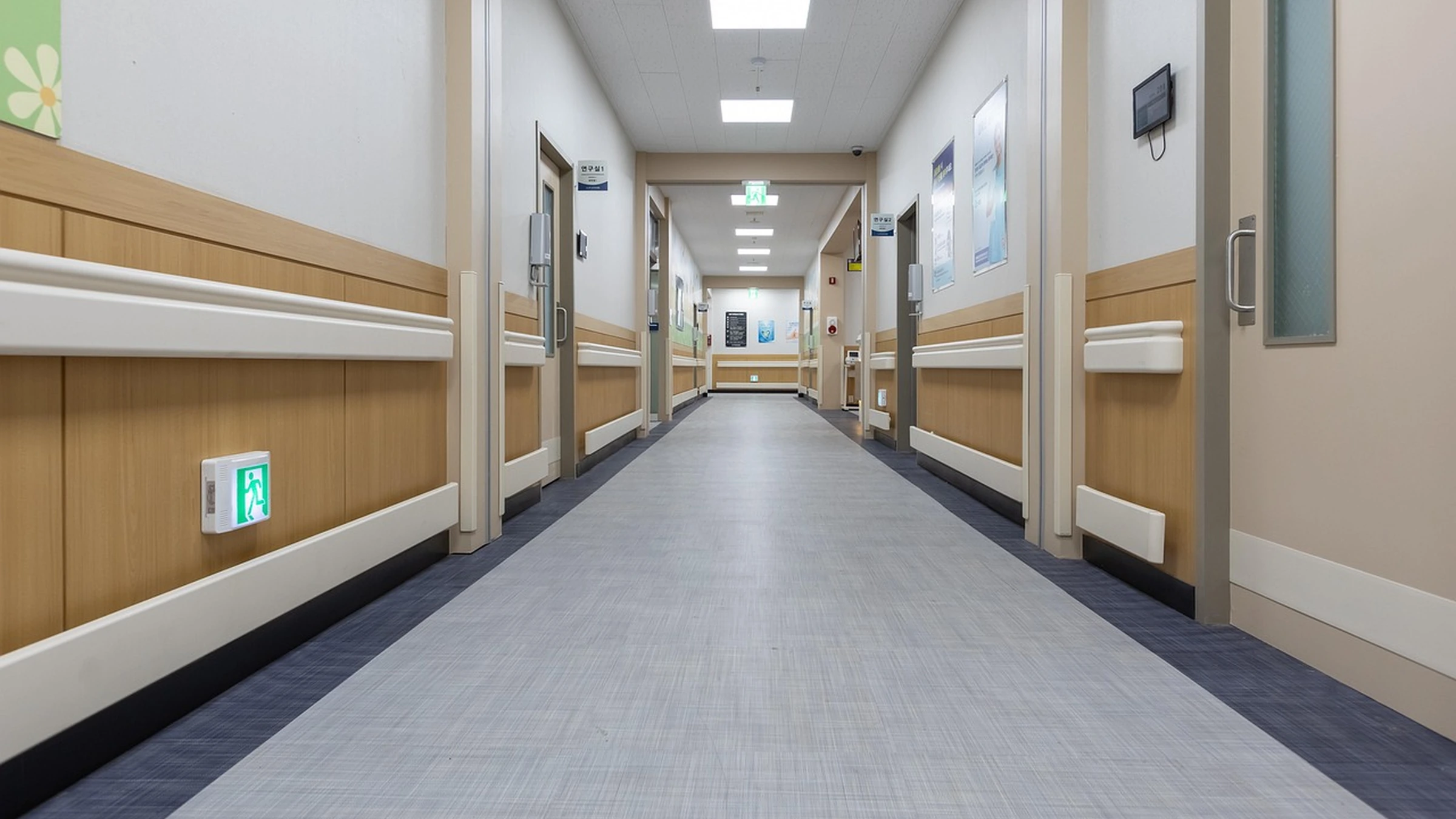 Empty modern hospital corridor with rooms on either side