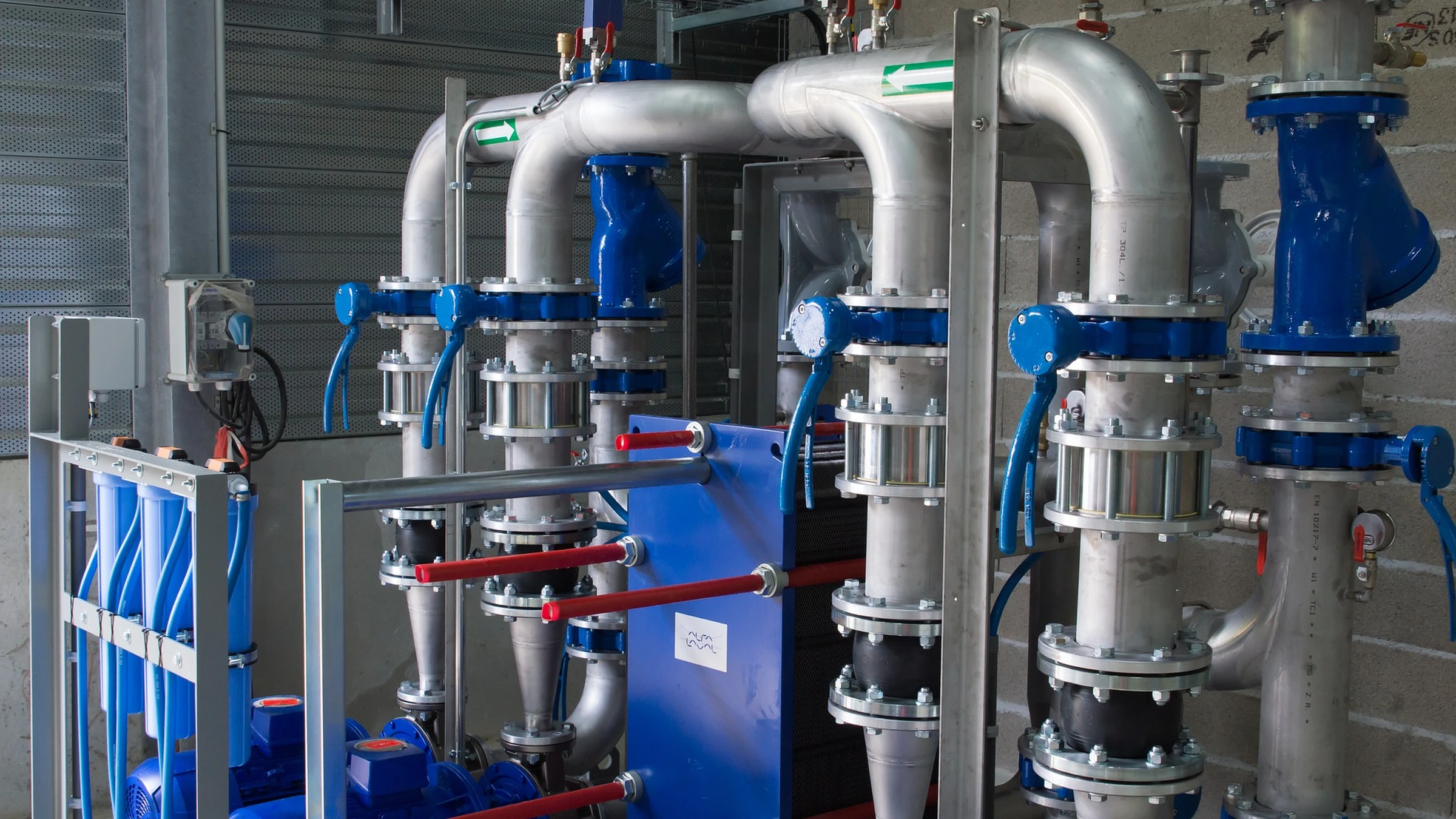 Industrial pump and valve assemblies with blue equipment and silver pipes.