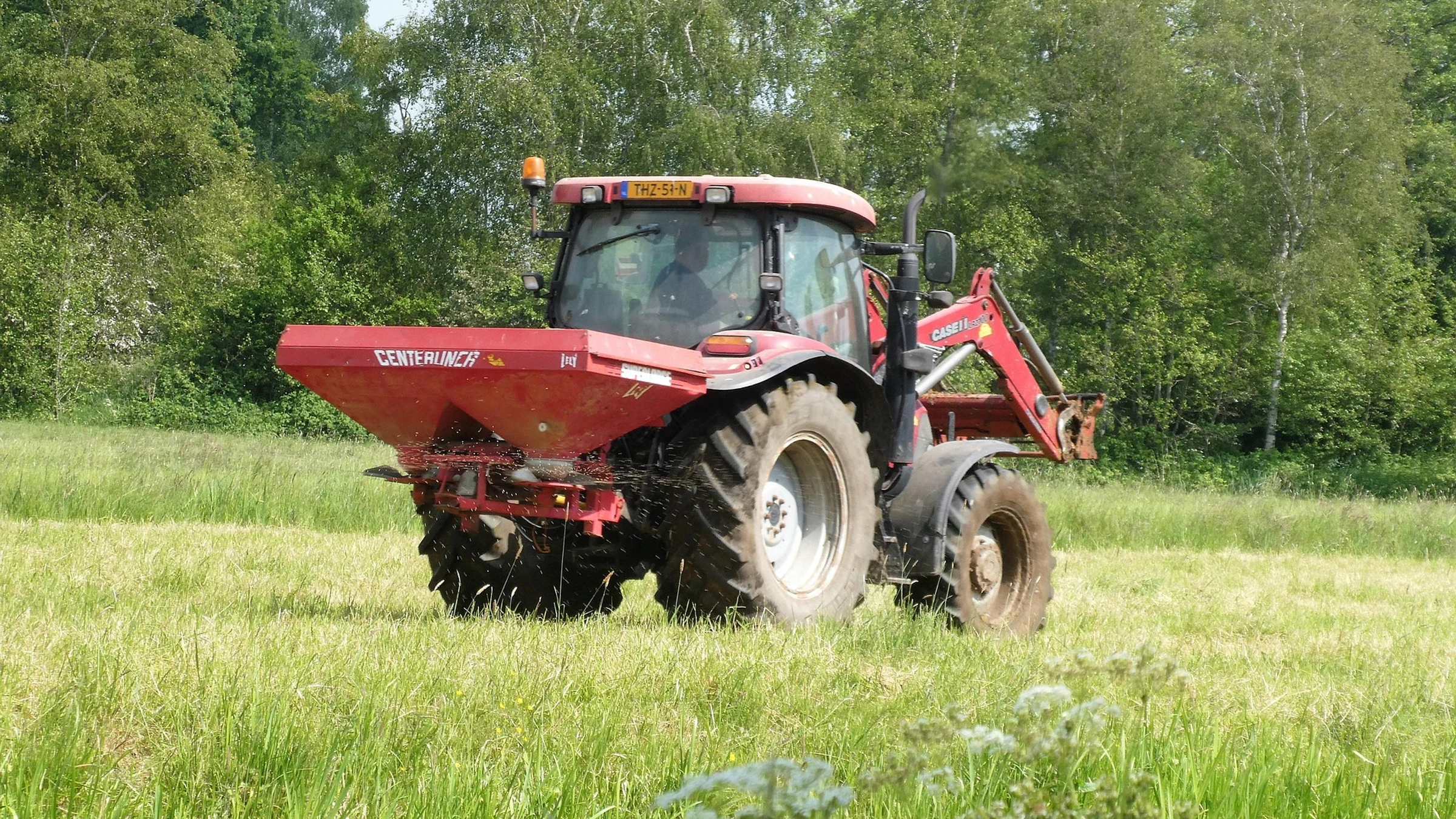 A tractor spreading fertilizer across a field.