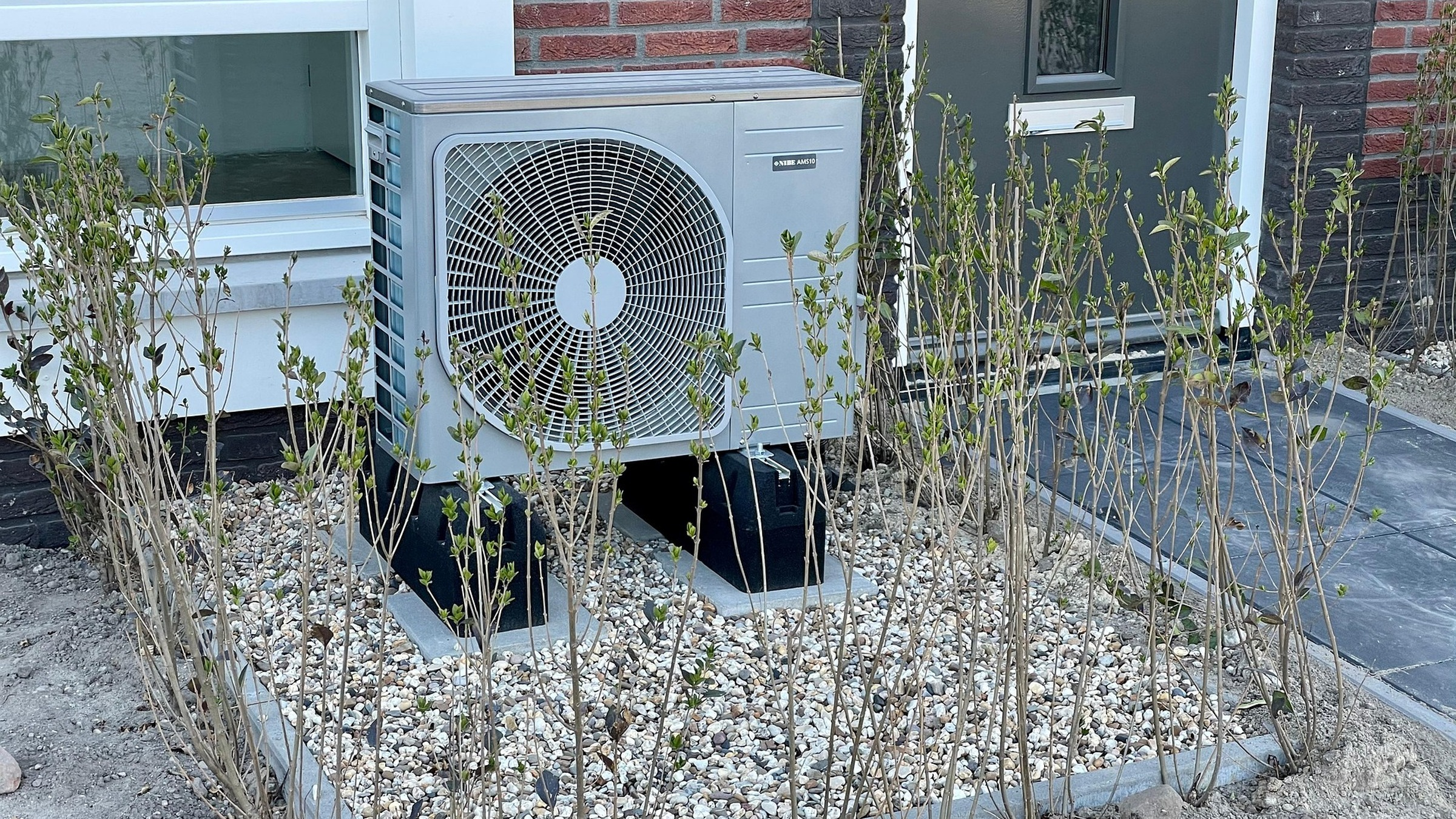 Outdoor heat pump equipment beside a house.