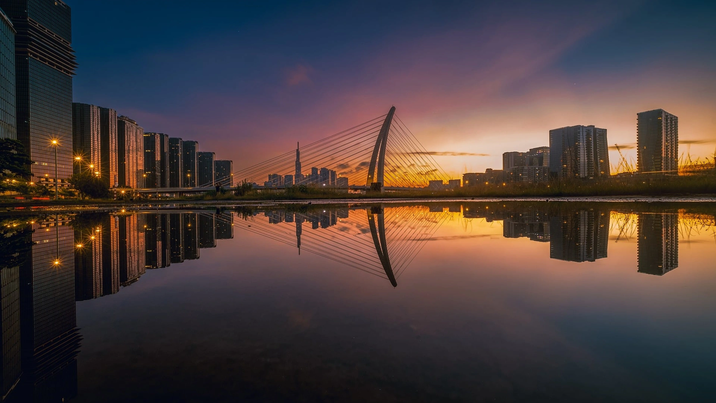 Ba Son Bridge and riverfront buildings in Ho Chi Minh City at sunset