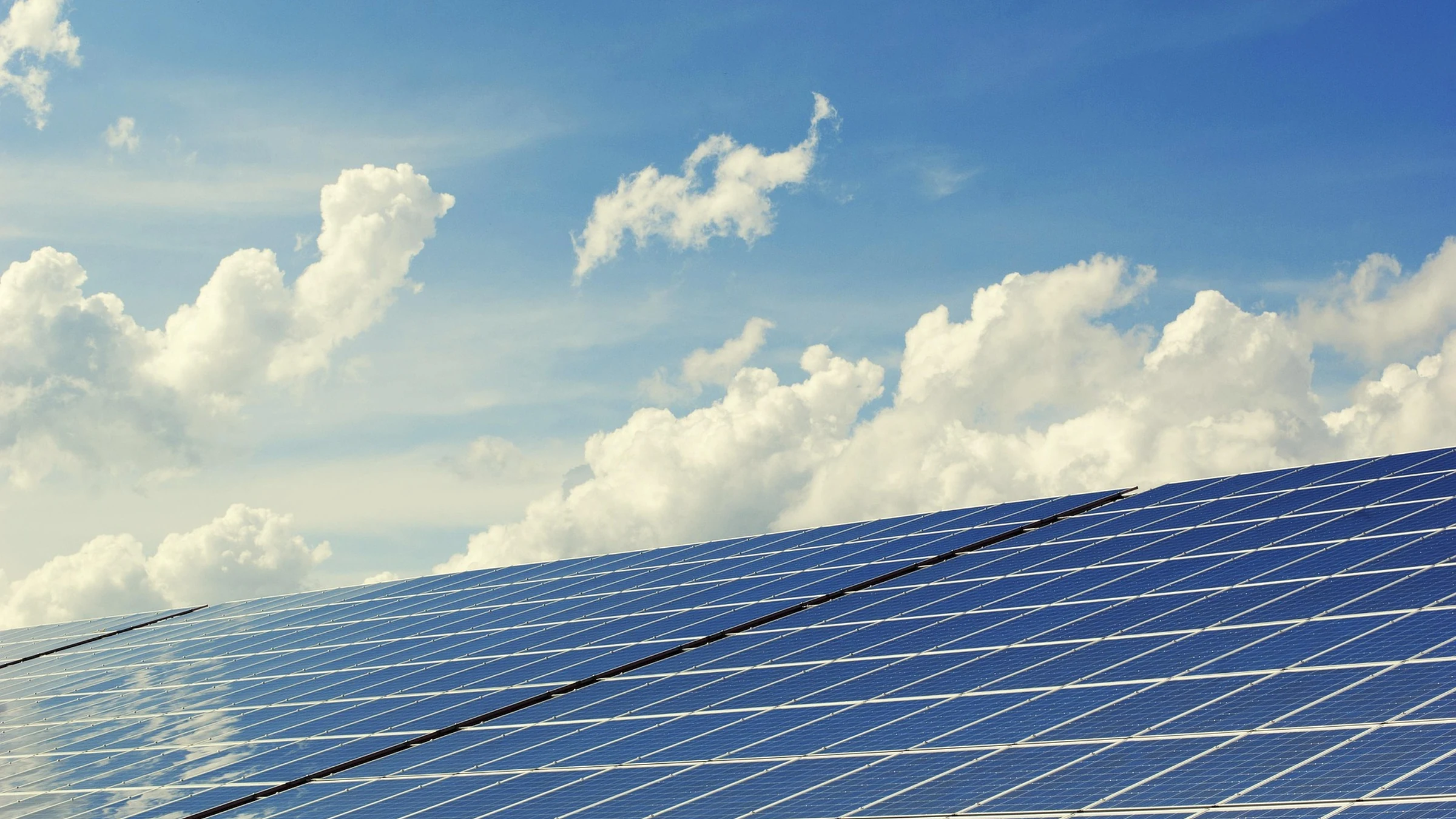 Photovoltaic solar modules beneath a blue and cloudy sky