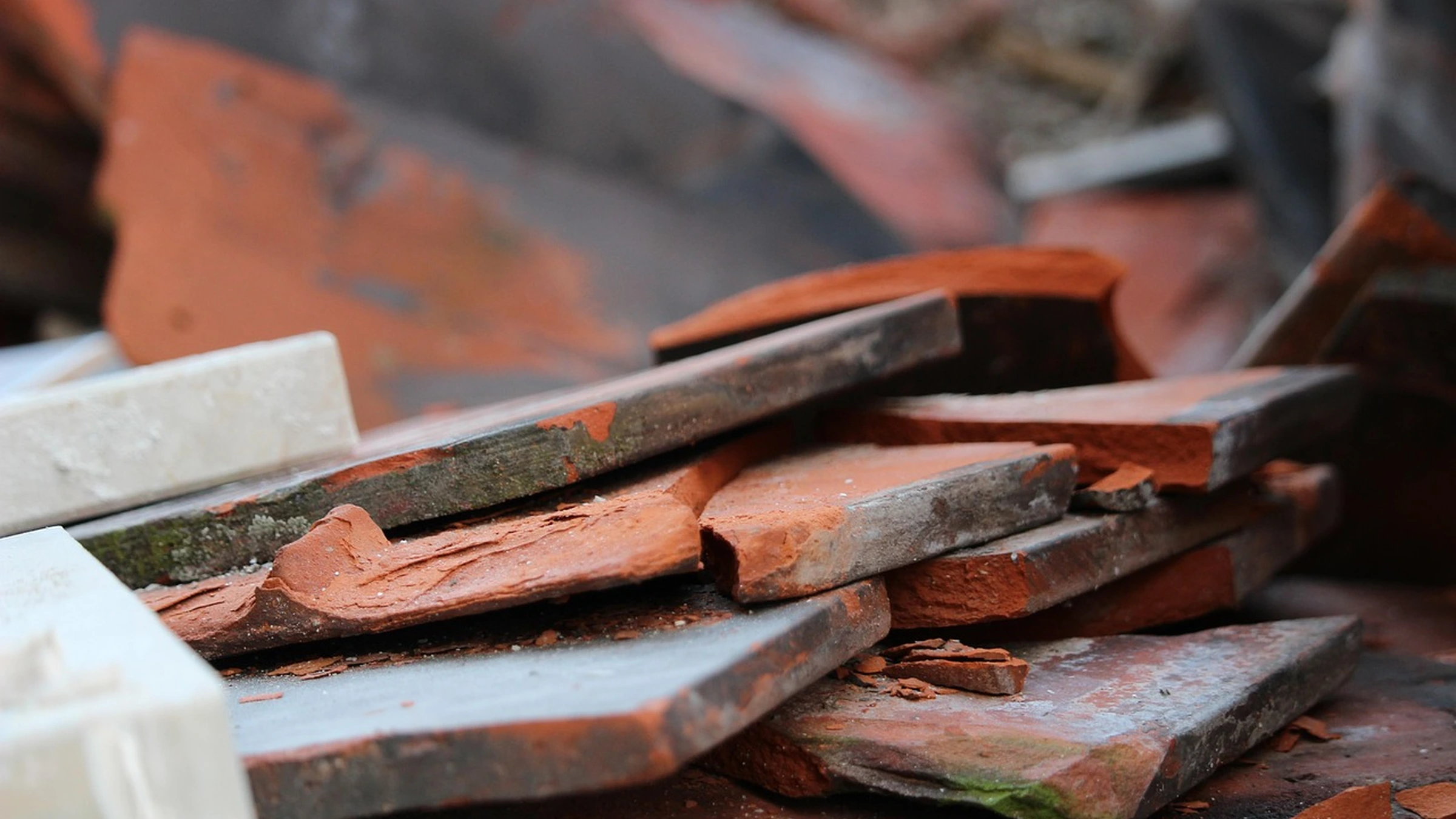 A pile of broken bricks and terracotta roof tiles.