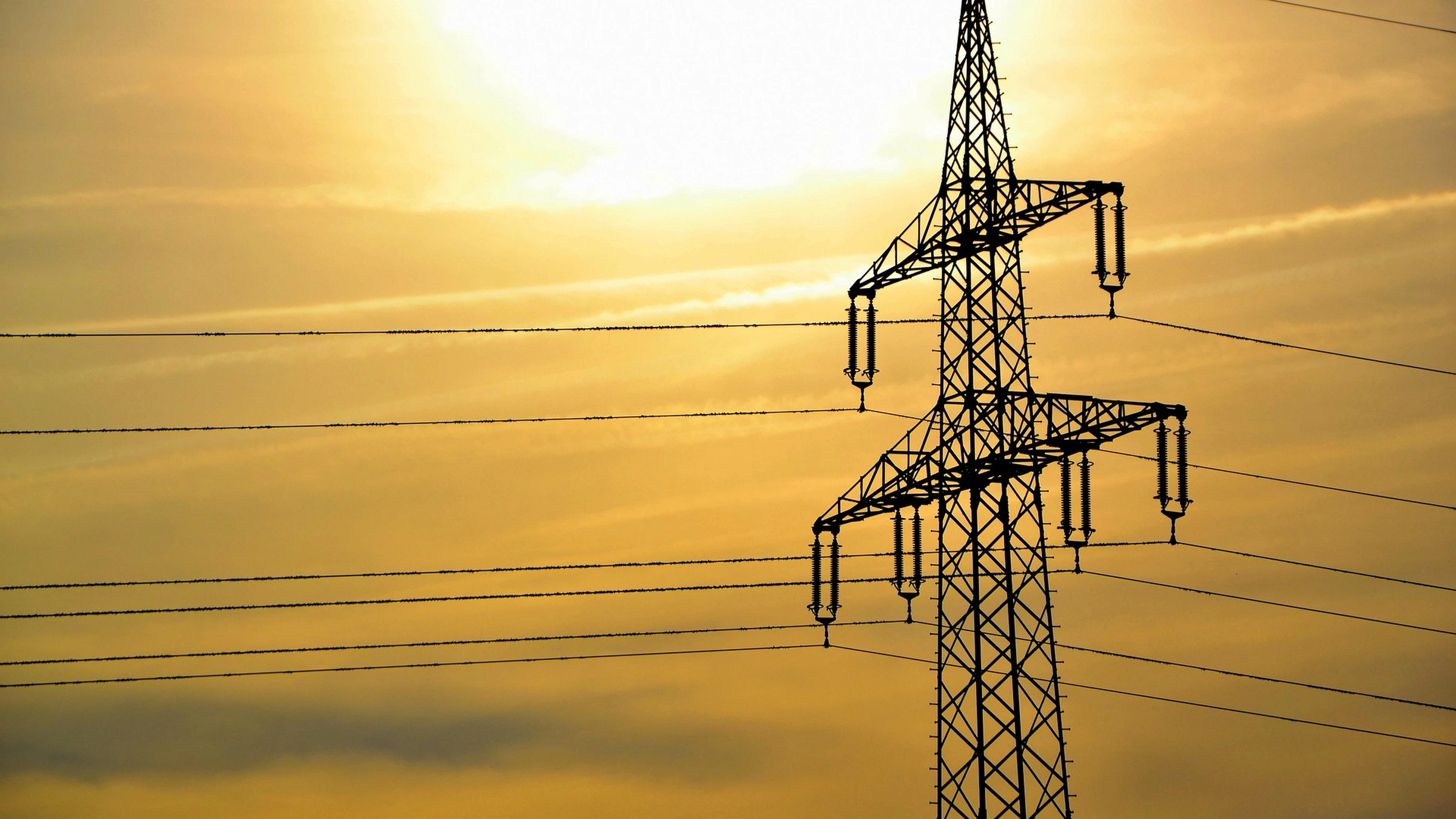 High-voltage transmission tower and wires at sunset