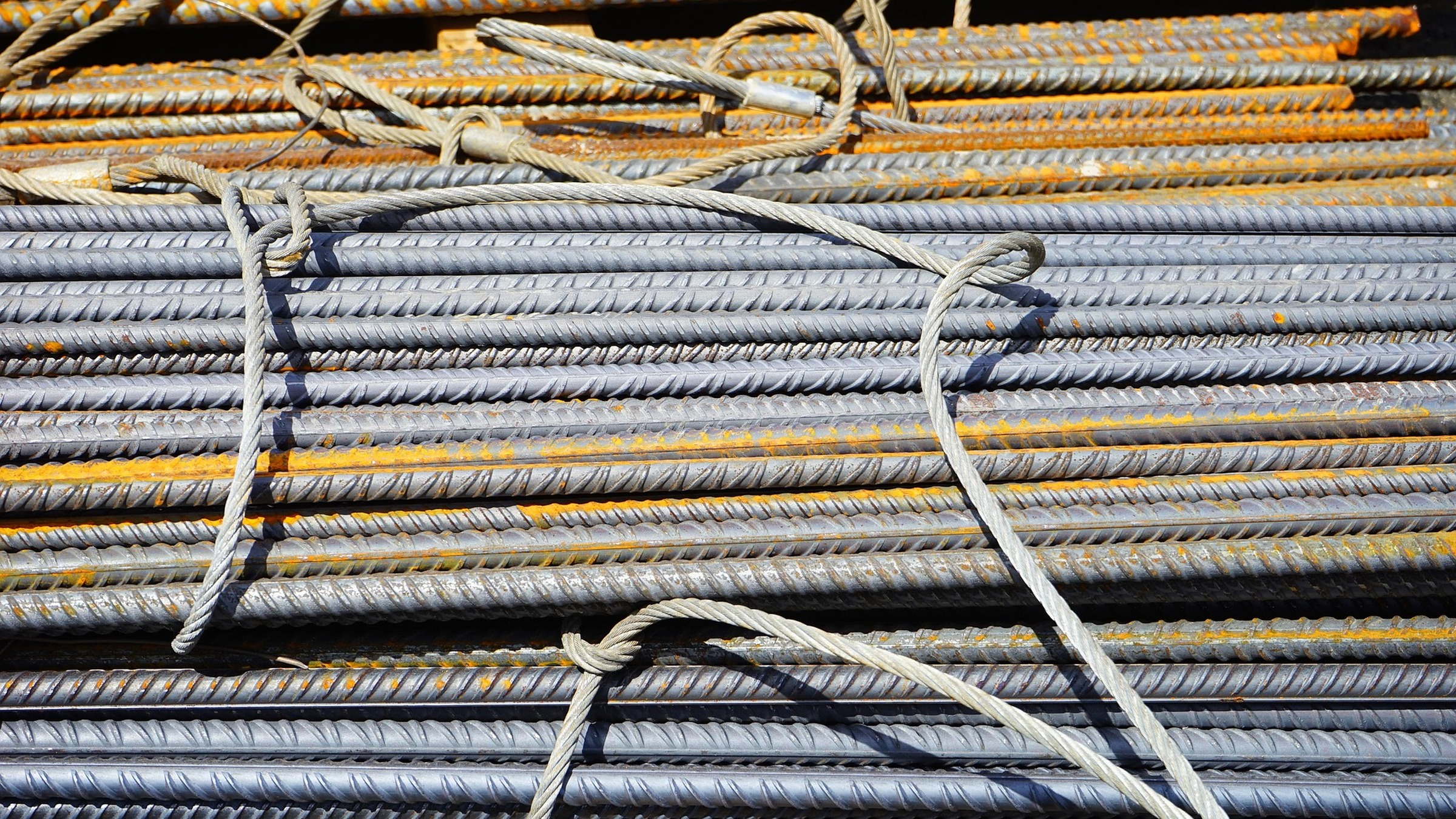 Bundles of ribbed reinforcing bars tied with rope.